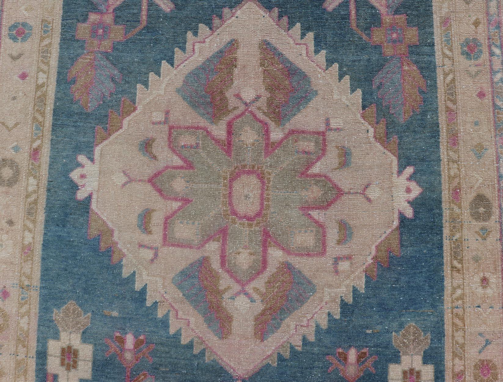 Measures: 3'9 x 10'2.
This antique Persian gallery Mahal rug has been hand-knotted in wool and features an all-over sub-geometric floral design rendered in blue, green, pink and neutral tones. A complementary, multi-tiered border encompasses the