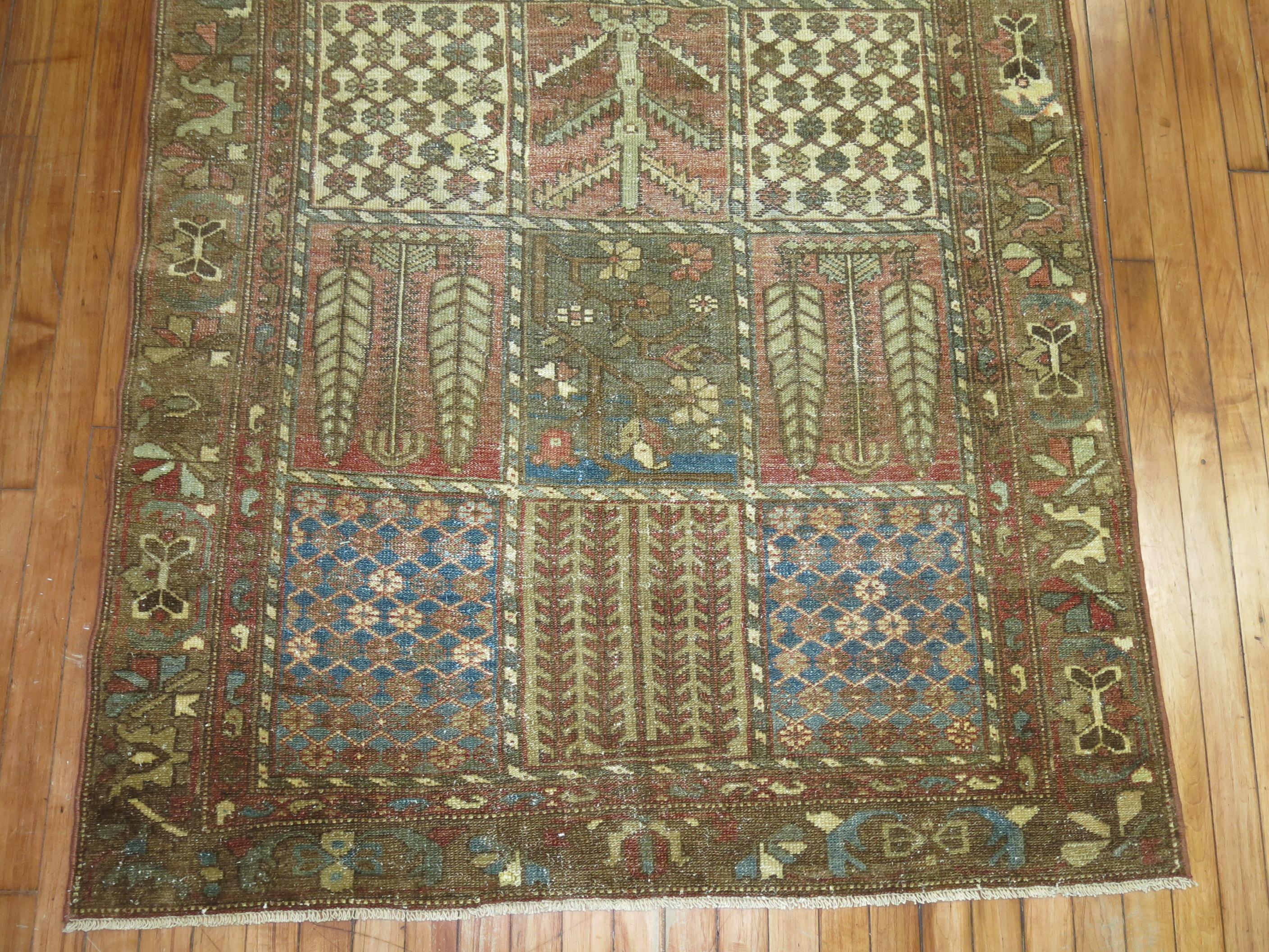 An antique Persian Bakhtiari rug with all-over garden box niche motif in earth tones