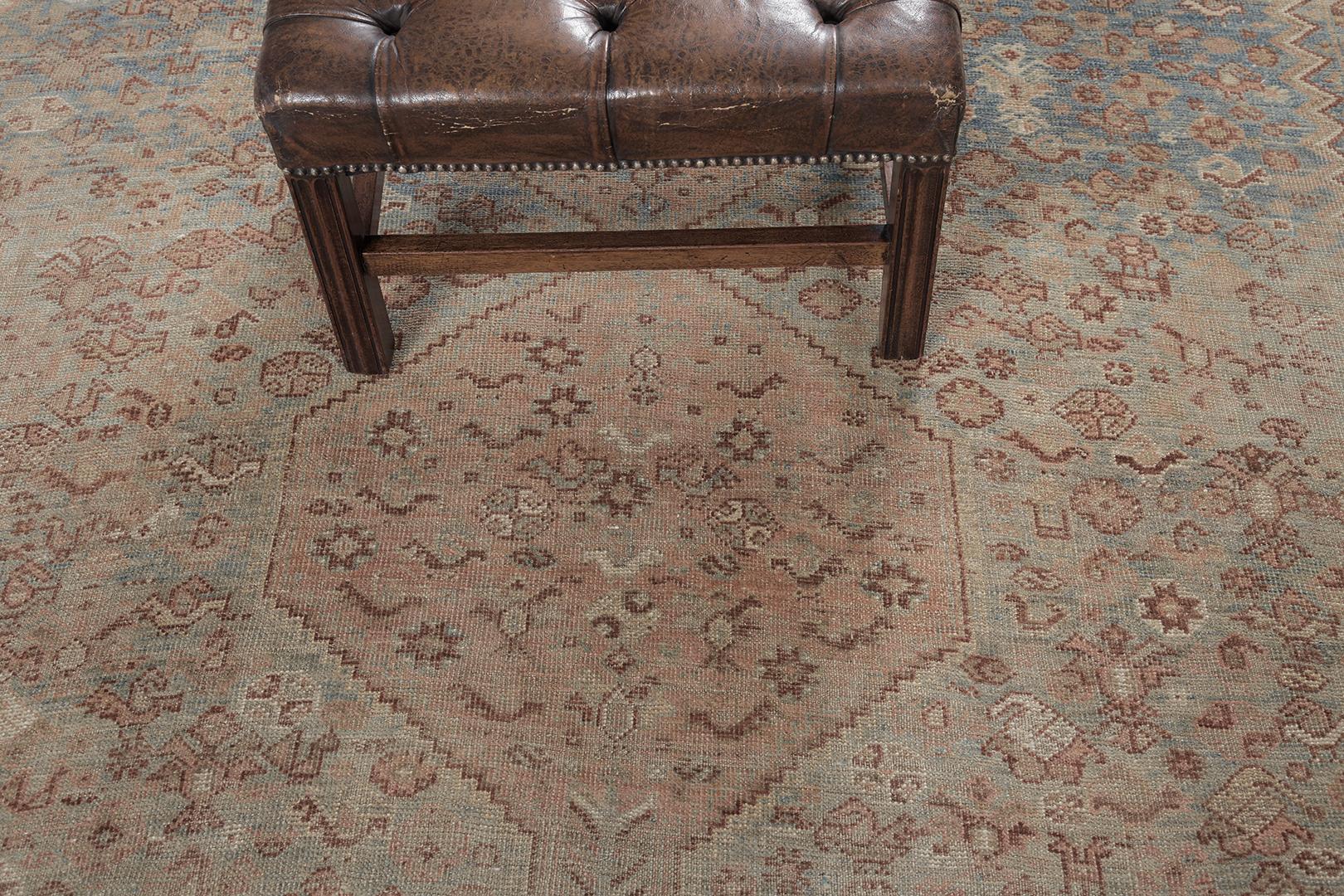 An elegant Antique Persian Ghashgaie rug that features timeless sophistication and nostalgic appeal. This enchanting rug is enclosed with a symbolical elements flanked with inner and outer guard bands. The abrashed turquoise ombre field is