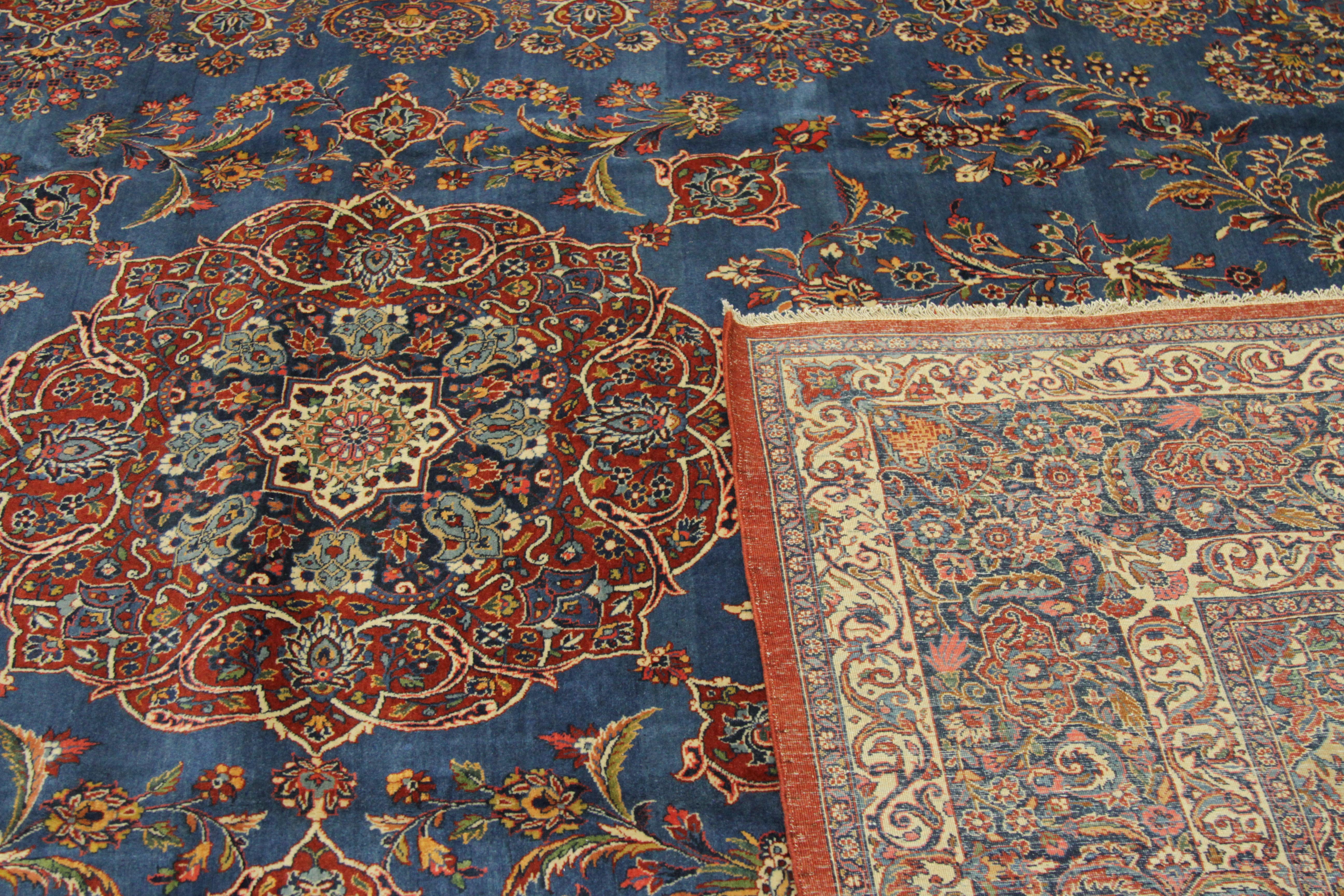 Wool Antique Persian Ghazvin Rug with Flower Medallion over a Blue Field, circa 1920s For Sale