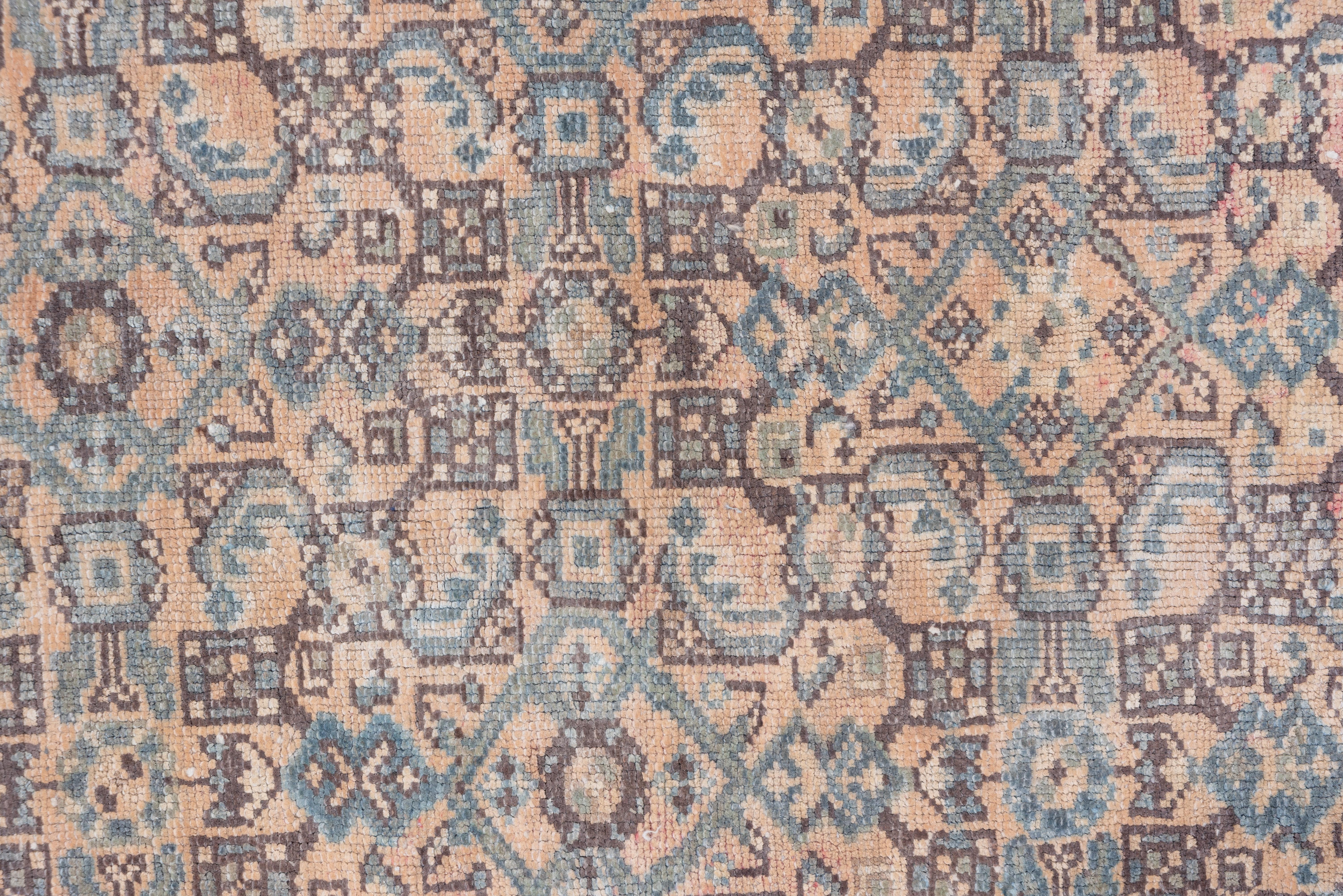 A small ivory octogramme medallion centers the stylized allover Herati pattern on the very closely covered ground mixing sage/slate blue a salmon pink. This west Persian carpet shows a narrow slate border with lancet l;eaves embracing palmettes.
 