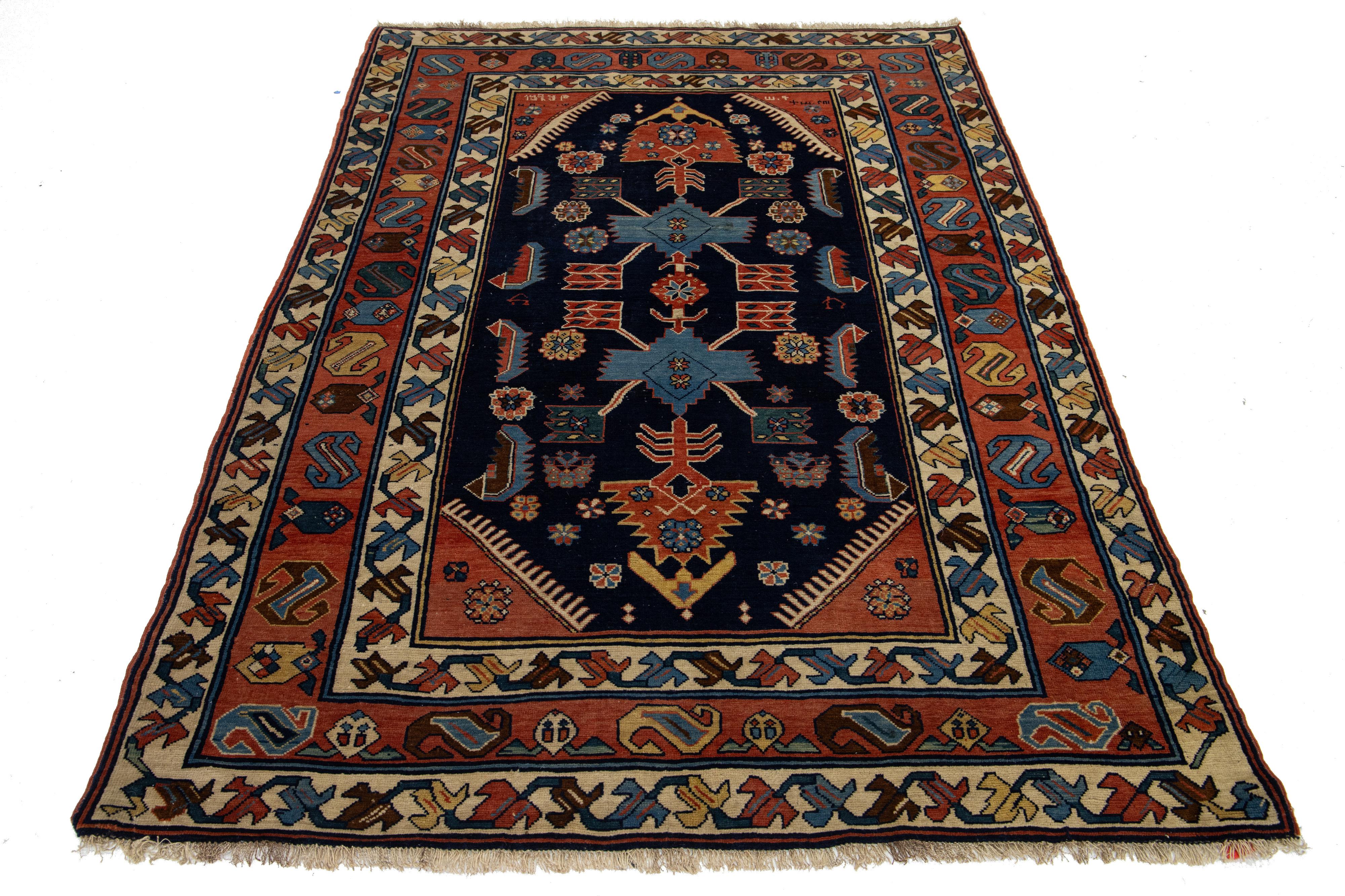 Beautiful antique Hamadan hand-knotted wool rug featuring a navy blue field. This Persian rug has a red and multicolored accent, showcasing a stunning all-over floral geometric design.

This rug measures 4'5