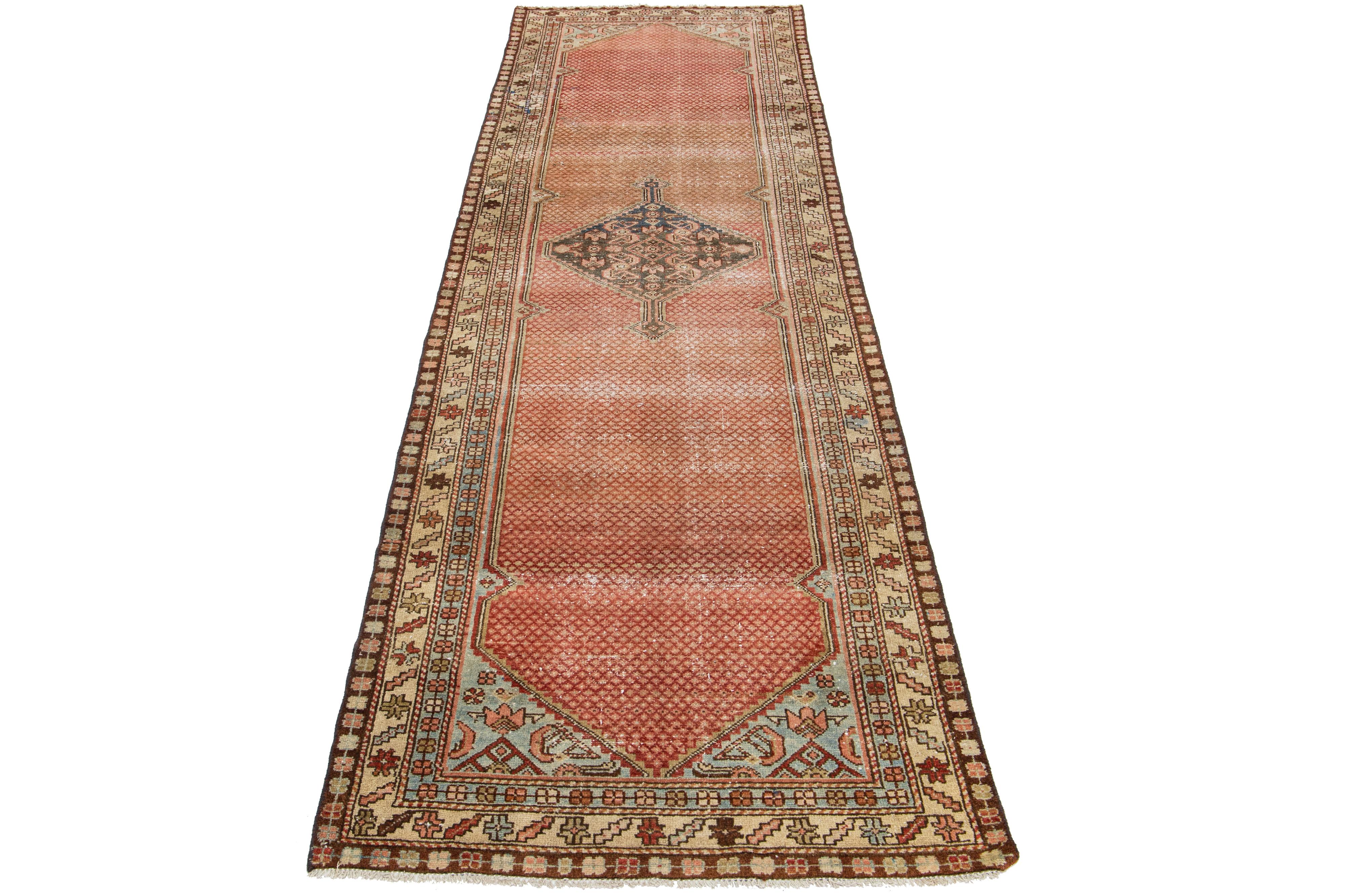 This antique Hamadan rug is hand-knotted from premium wool, boasting a rust field complemented by a captivating, all-over pattern design with blue and brown accents.

This rug measures 3'3
