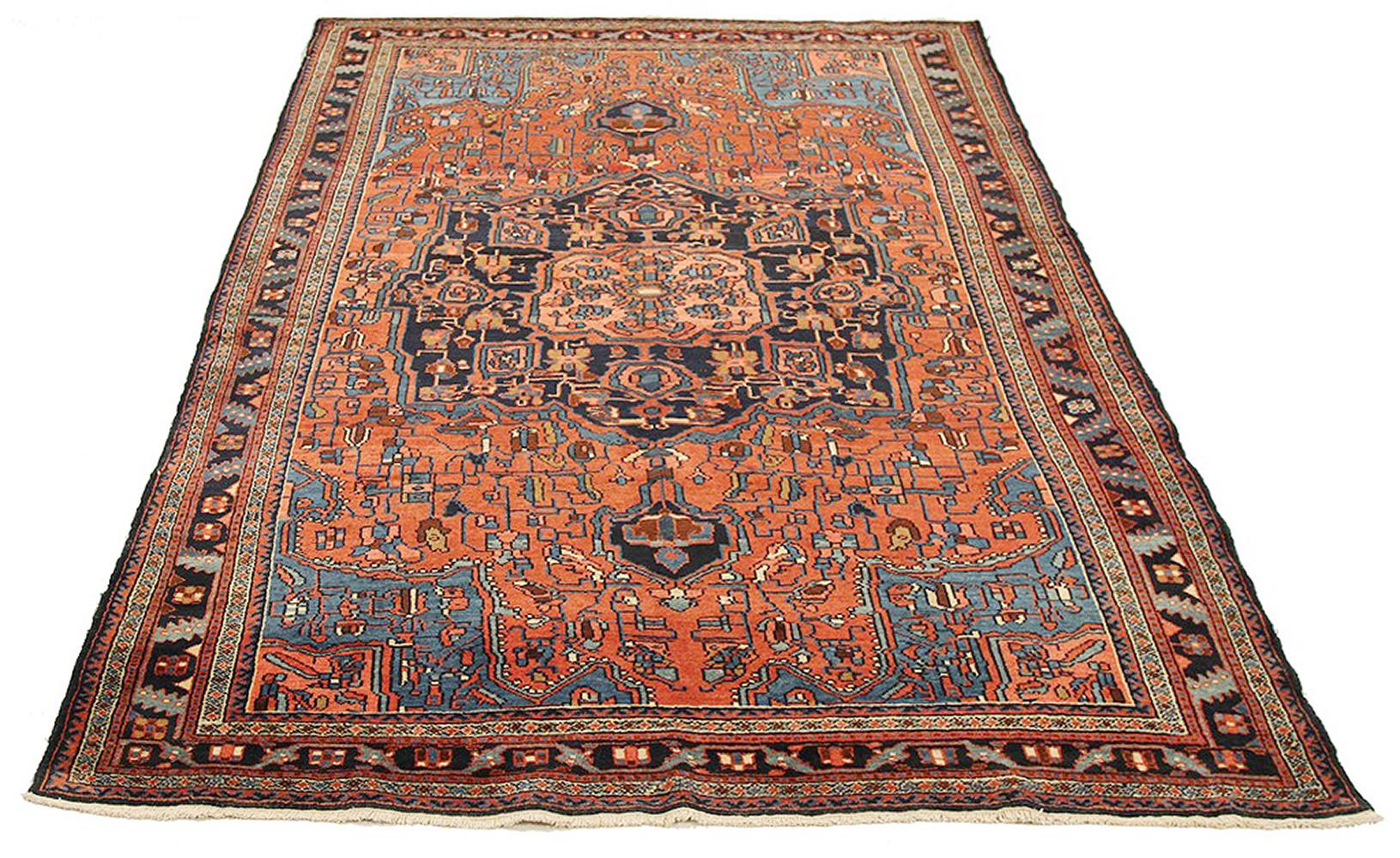 Antique Persian rug handwoven from the finest sheep’s wool and colored with all-natural vegetable dyes that are safe for humans and pets. It’s a traditional Hamedan design featuring floral patterns in red and blue on a black field. The details are