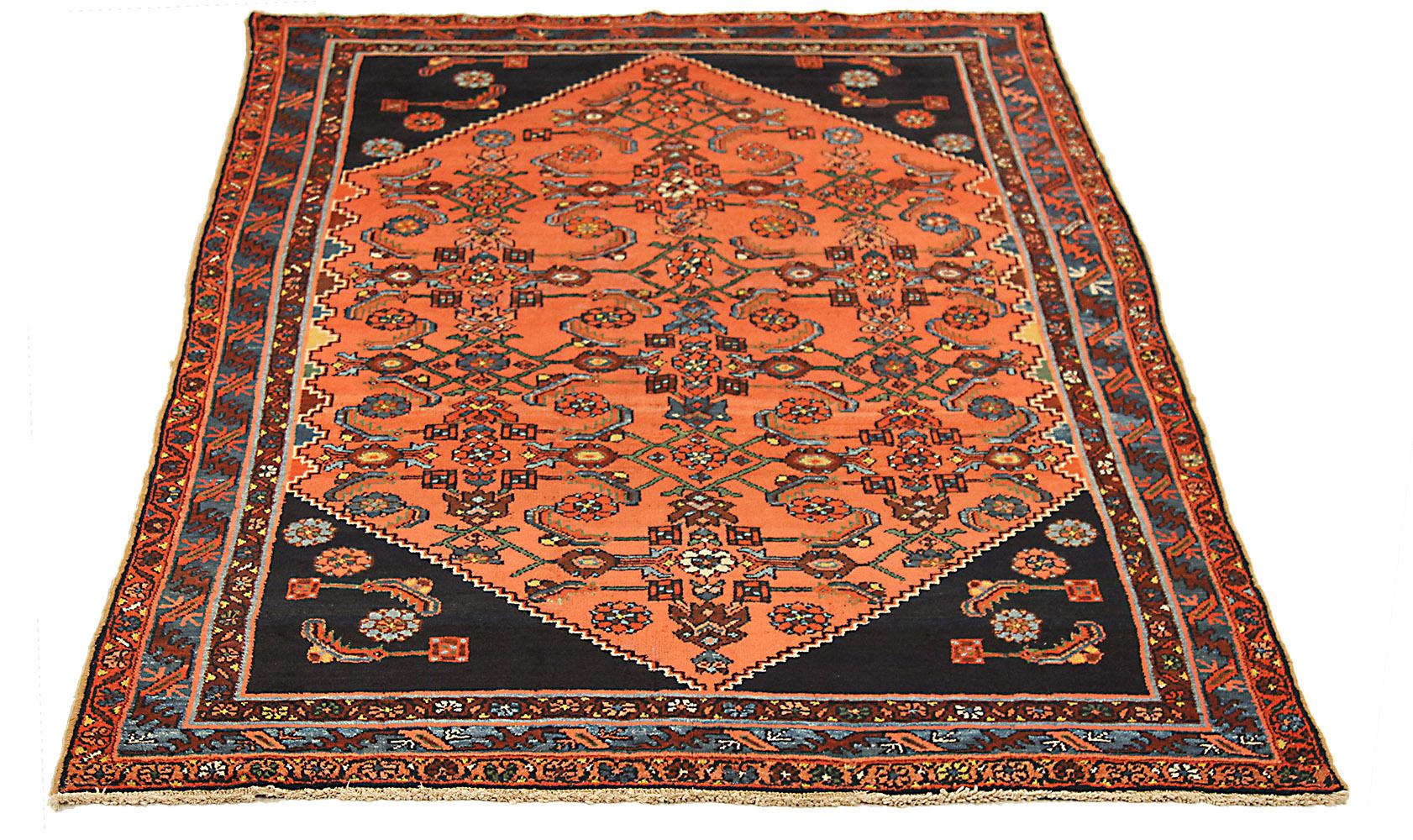 Antique Persian rug handwoven from the finest sheep’s wool and colored with all-natural vegetable dyes that are safe for humans and pets. It’s a traditional Hamadan design featuring floral patterns in brown and blue over an orange and black field.