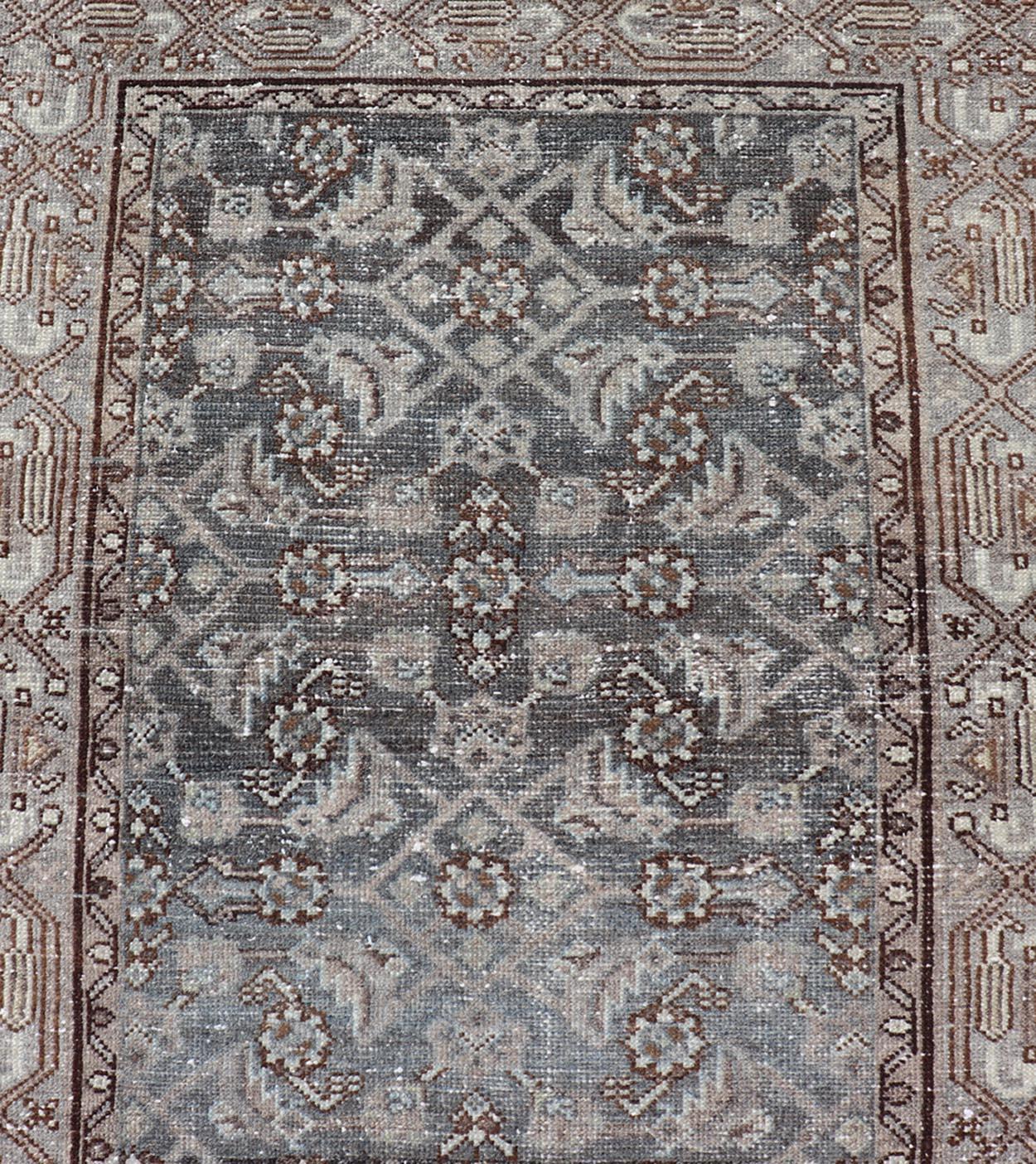 This antique Persian Hamadan rug has been hand-knotted in wool and features an all-over sub-geometric design rendered in multicolor. A complementary, multi-tiered border encompasses the entirety of the piece; making it a marvelous fit for a wide