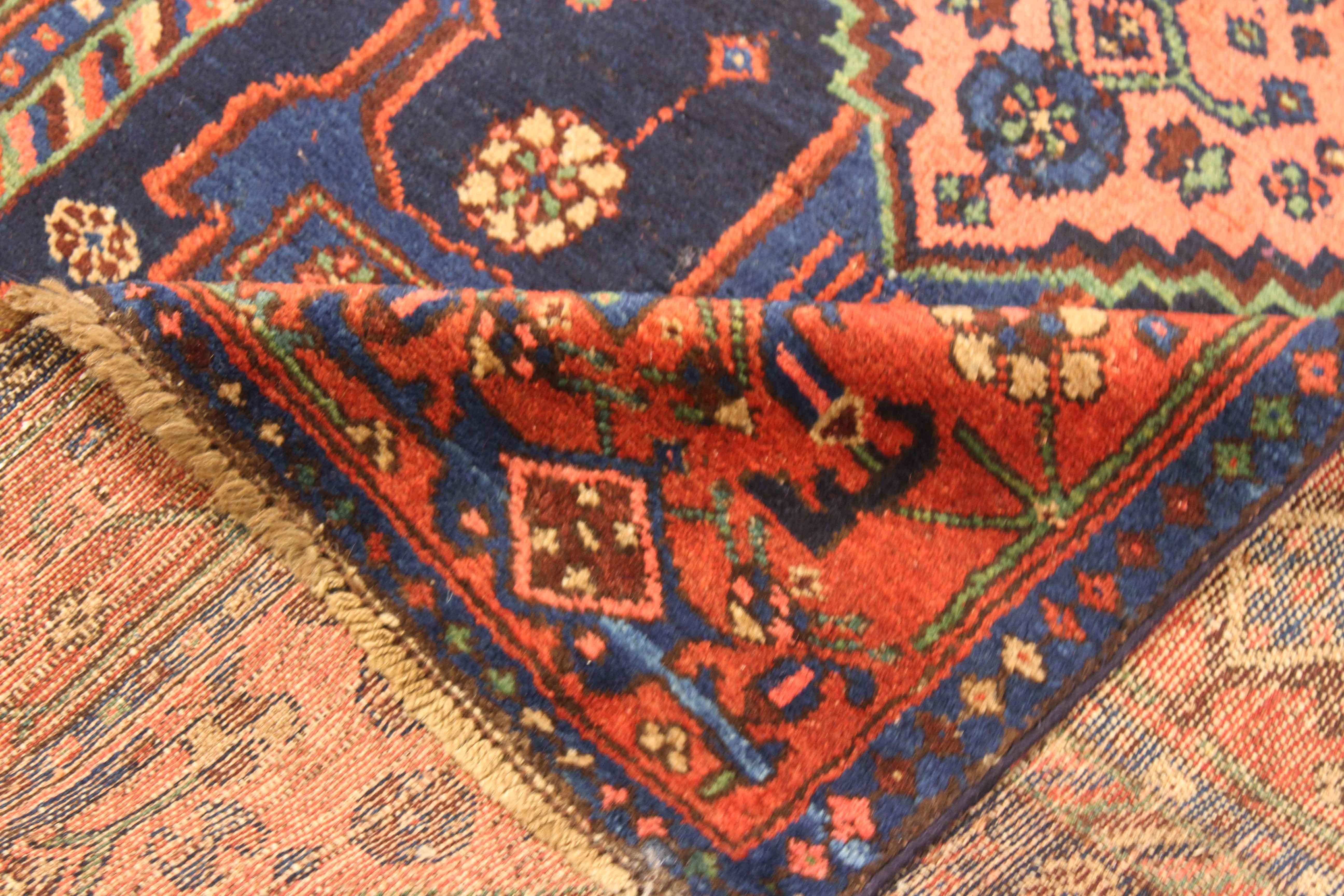 Antique Persian rug handwoven from the finest sheep’s wool and colored with all-natural vegetable dyes that are safe for humans and pets. It’s a traditional Hamedan design featuring a bold mix of red, blue and beige. It has a unique set of ‘anchor’