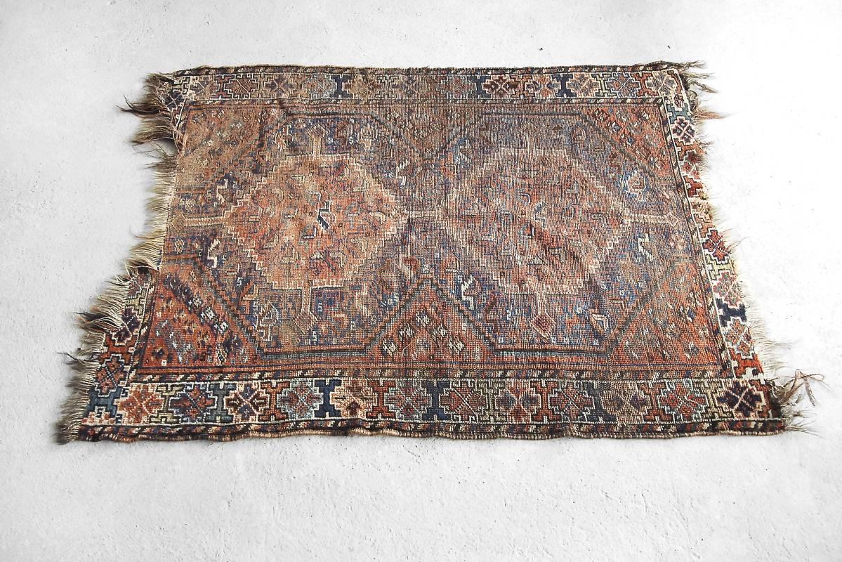 This antique handmade Shiraz rug was manufactured, circa1850 in Persia. The rug is in traditional deeply brown and dark blue colors with a geometric, tribal pattern. This hand-knotted carpet is unique and the pattern is typical for nomads with