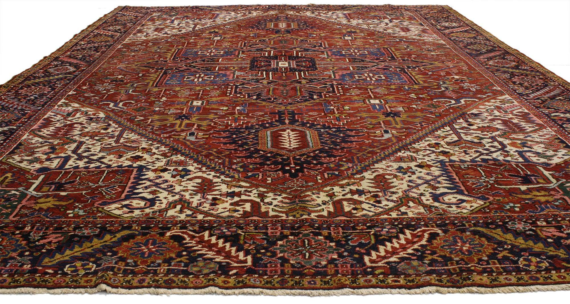 77030, antique Persian Heriz area rug. Artfully hand-knotted from high quality wool, this hand-knotted wool antique Persian Heriz rug features a classic traditional style comprised of a prominent central medallion flanked with two cartouche finials
