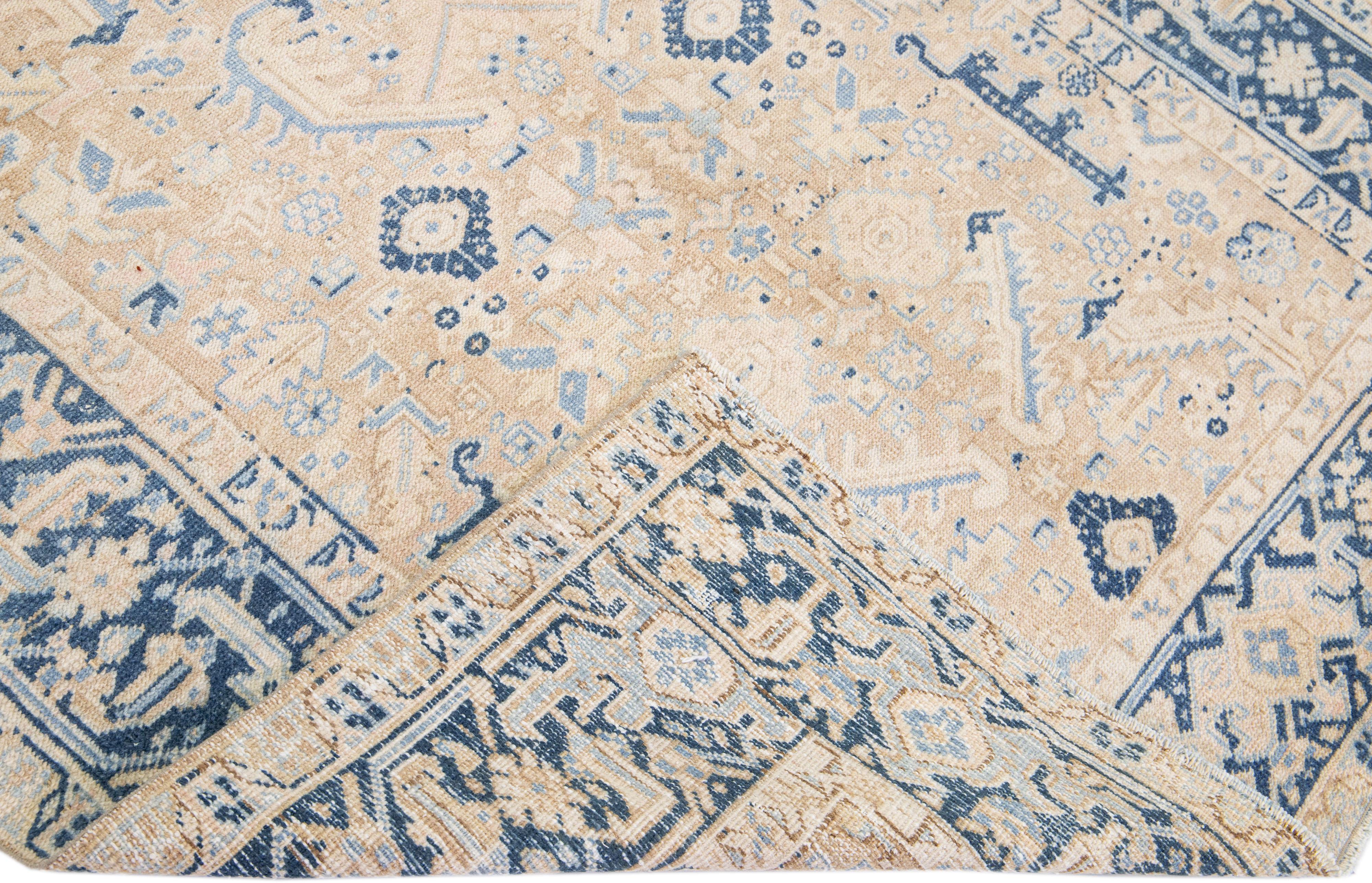 Beautiful antique Heriz hand-knotted wool rug with a beige color field. This Persian rug has a blue frame with tan accents in a gorgeous all-over geometric medallion design.

This rug measures: 5'10