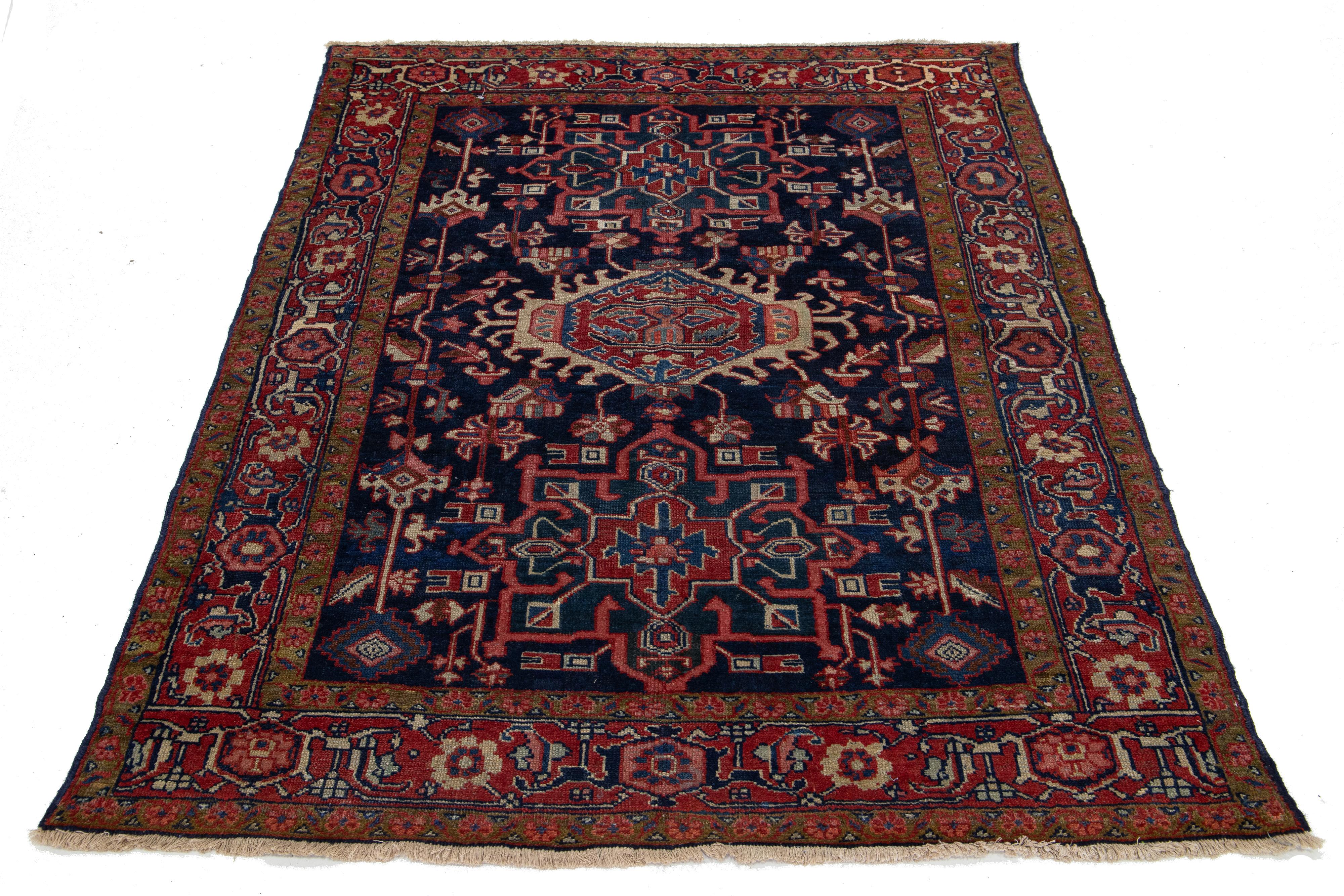 Discover the beauty of this antique Persian Heriz wool rug. Its stunning multicolor medallion design brings life to a luxurious, deep blue background.

This rug measures 4'3'' x 5'2