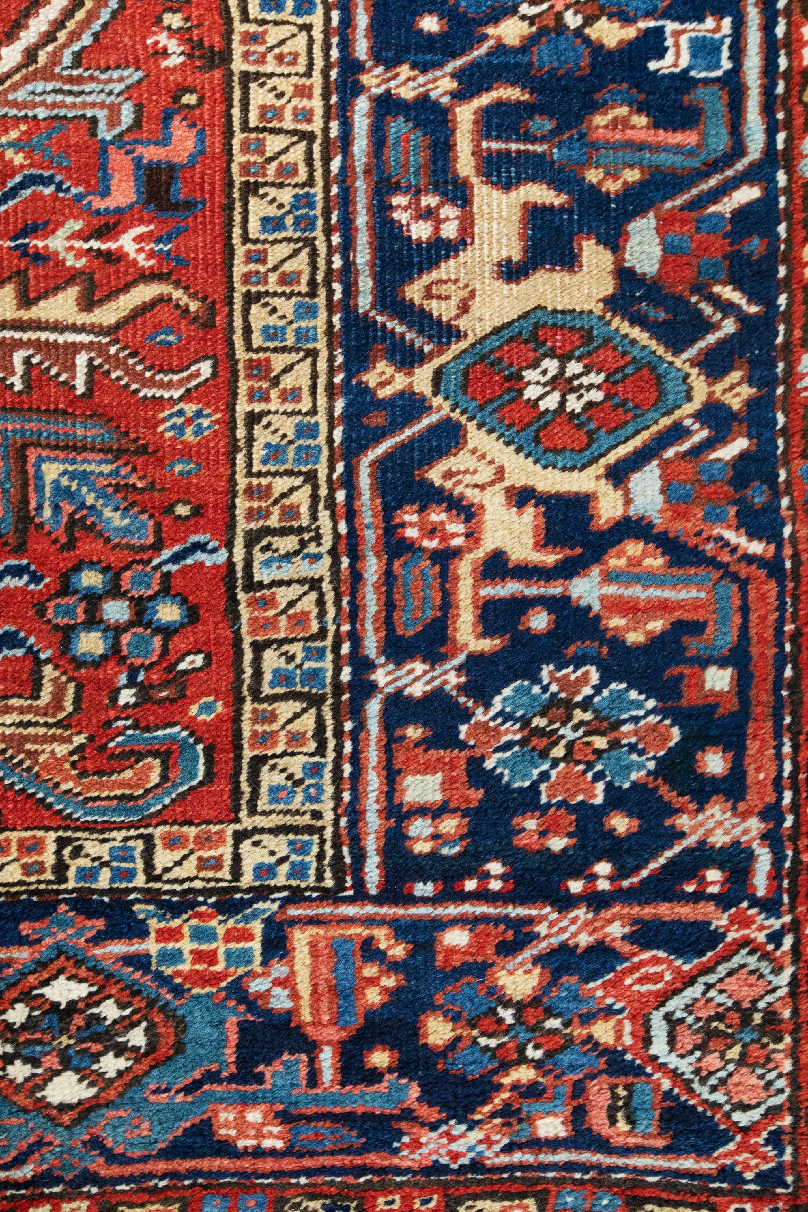 Antigua alfombra persa Heriz, borde azul marino sobre campo rojo, hacia 1930 Persa en venta