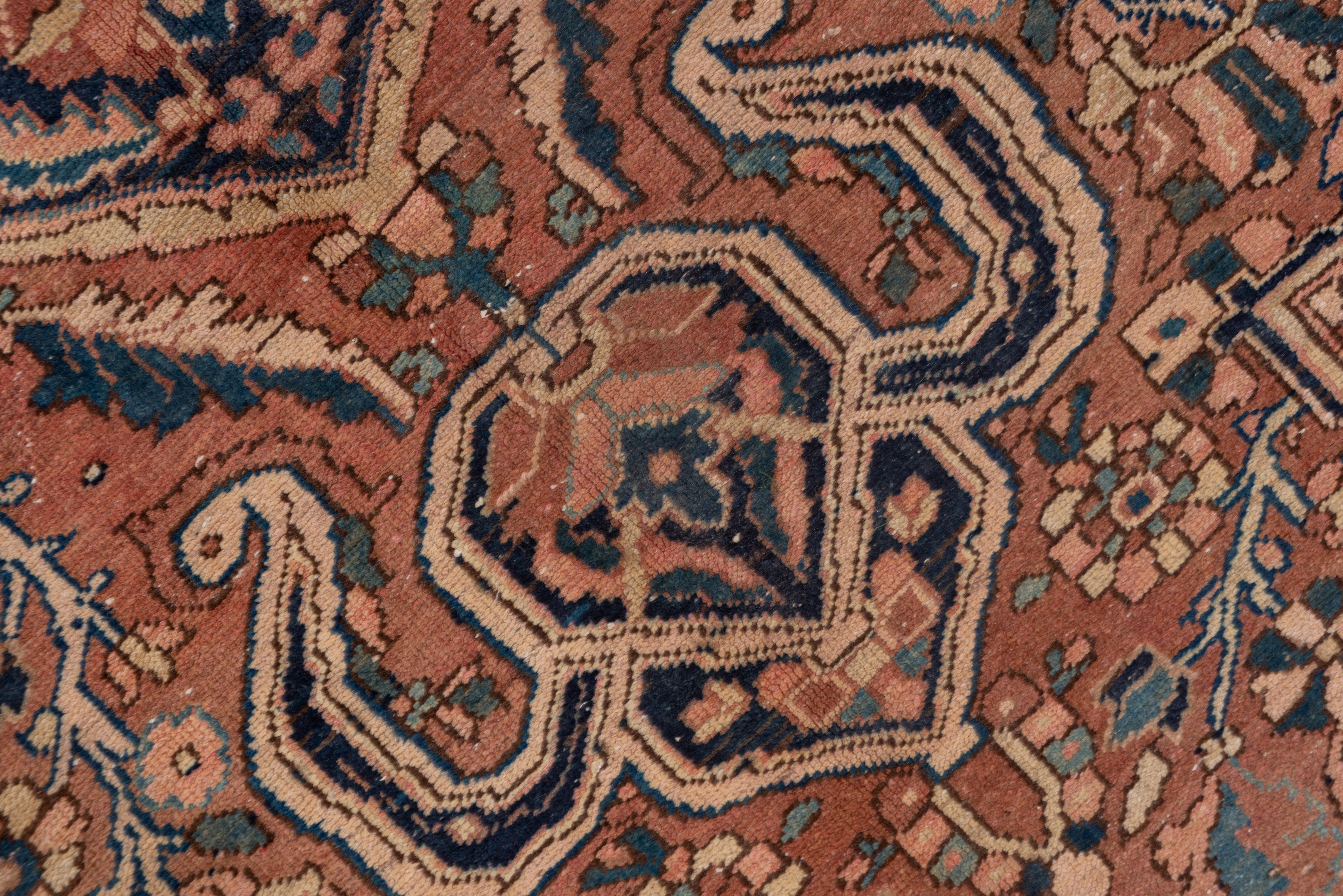 Of Ahar quality, this NW Persian village carpet shows a shaped rose field anchored by a huge navy octofoil medallion. In the ivory corners, the oval palmettes project into the field, locking the composition together. The navy border shows 16-lobe