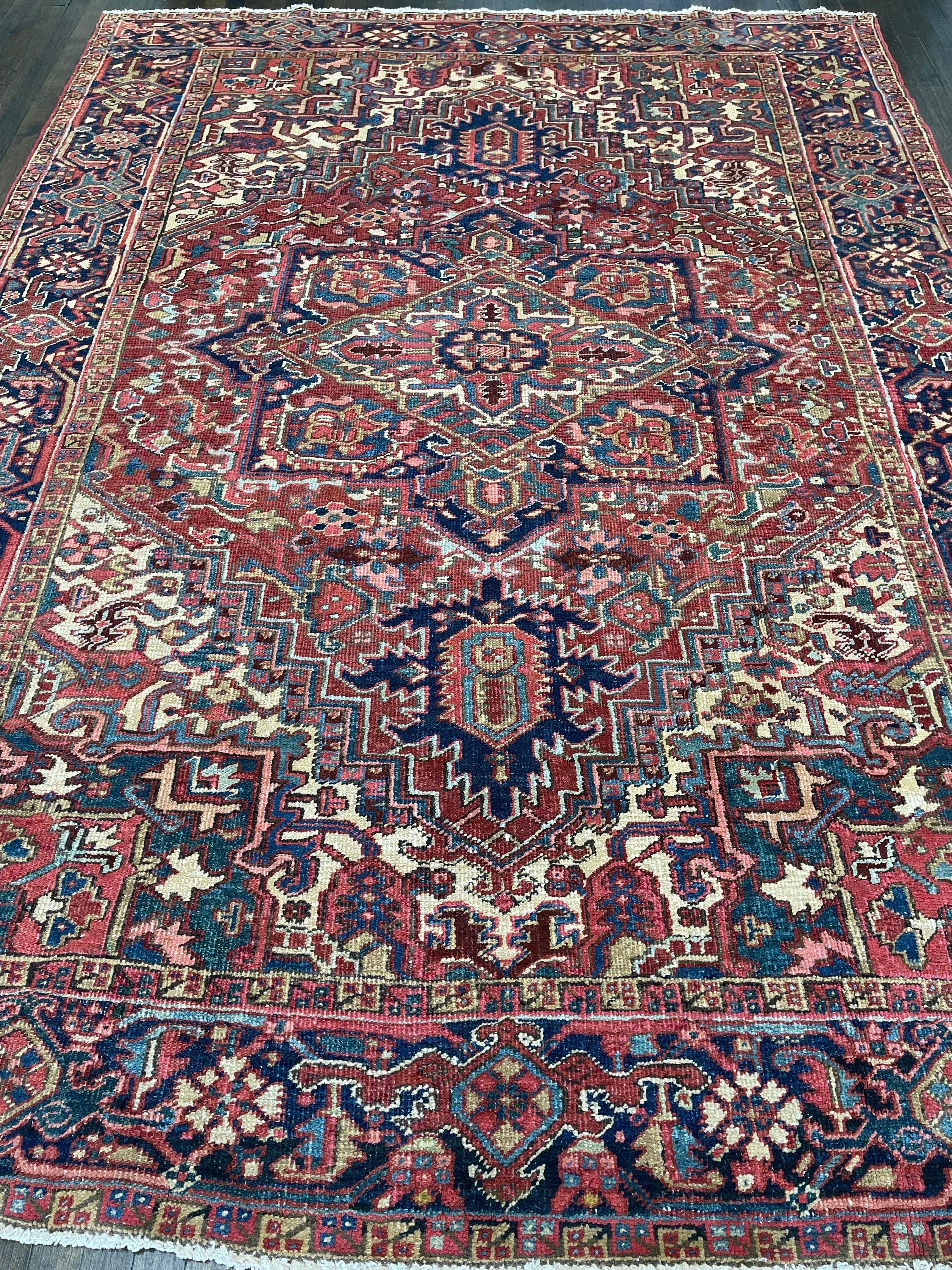 A very handsome Persian Heriz featuring a terracotta /rust field decorated with a medallion and surrounded with four corners of beautiful green and navy blue border.The background  of the rug is designed with many geometric devices and the border