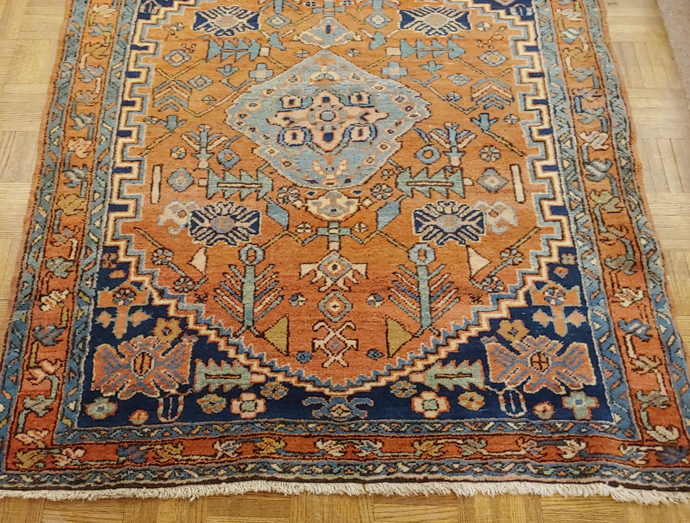 A striking small Persian Heriz in a scatter size 3-6 x 4-6 from circa 1915. A light blue medallion on a soft rust field with a geometric motif.