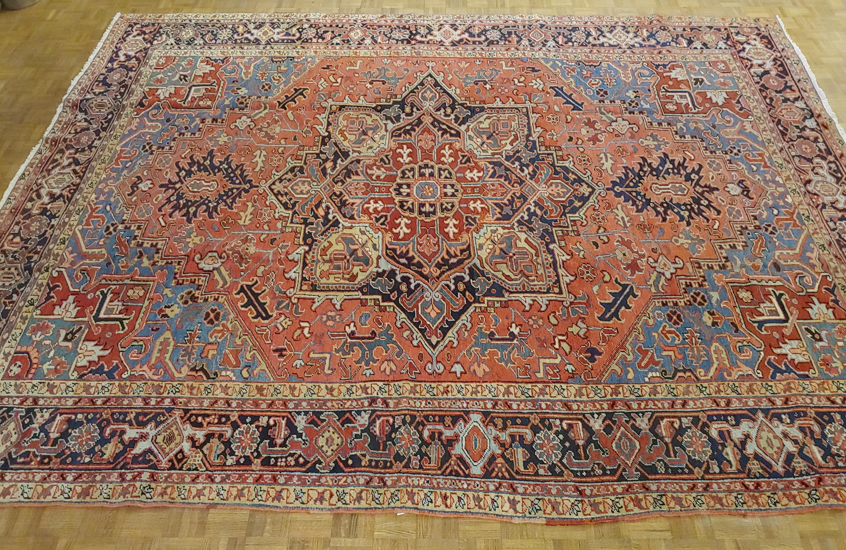 This is a gracious and beautiful Persian Heriz (though lots of dealers would call it a Serapi). The field is coral background with light blue spandrels and a Herati motif border with navy background. Very decorative piece, circa 1915. It is 9-6 x 12.