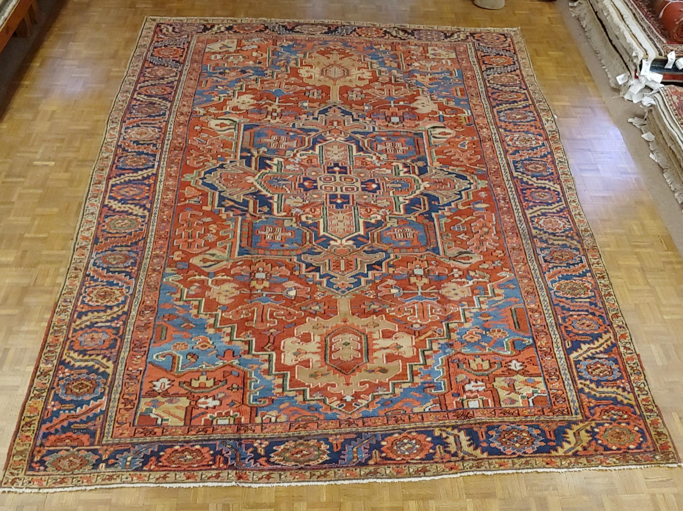 This is a gracious and beautiful Persian Heriz (though lots of dealers would call it a Serapi). The field is rust with light blue spandrels and a wonderful flowers and leaves motif border with navy background. The design also uses lots of beautiful
