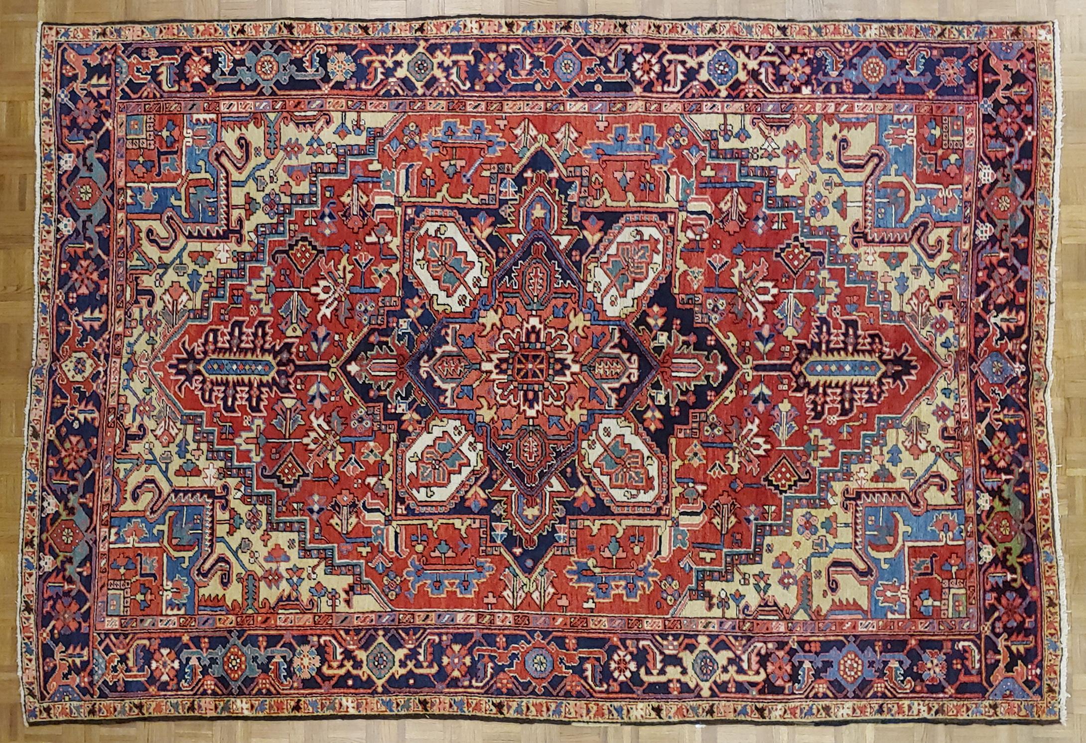 This is a gracious and beautiful Persian Heriz (though lots of dealers would call it a Serapi). The field is rust with unusual gold spandrels and a Herati motif border with navy background. The design also uses lots of beautiful light blue and