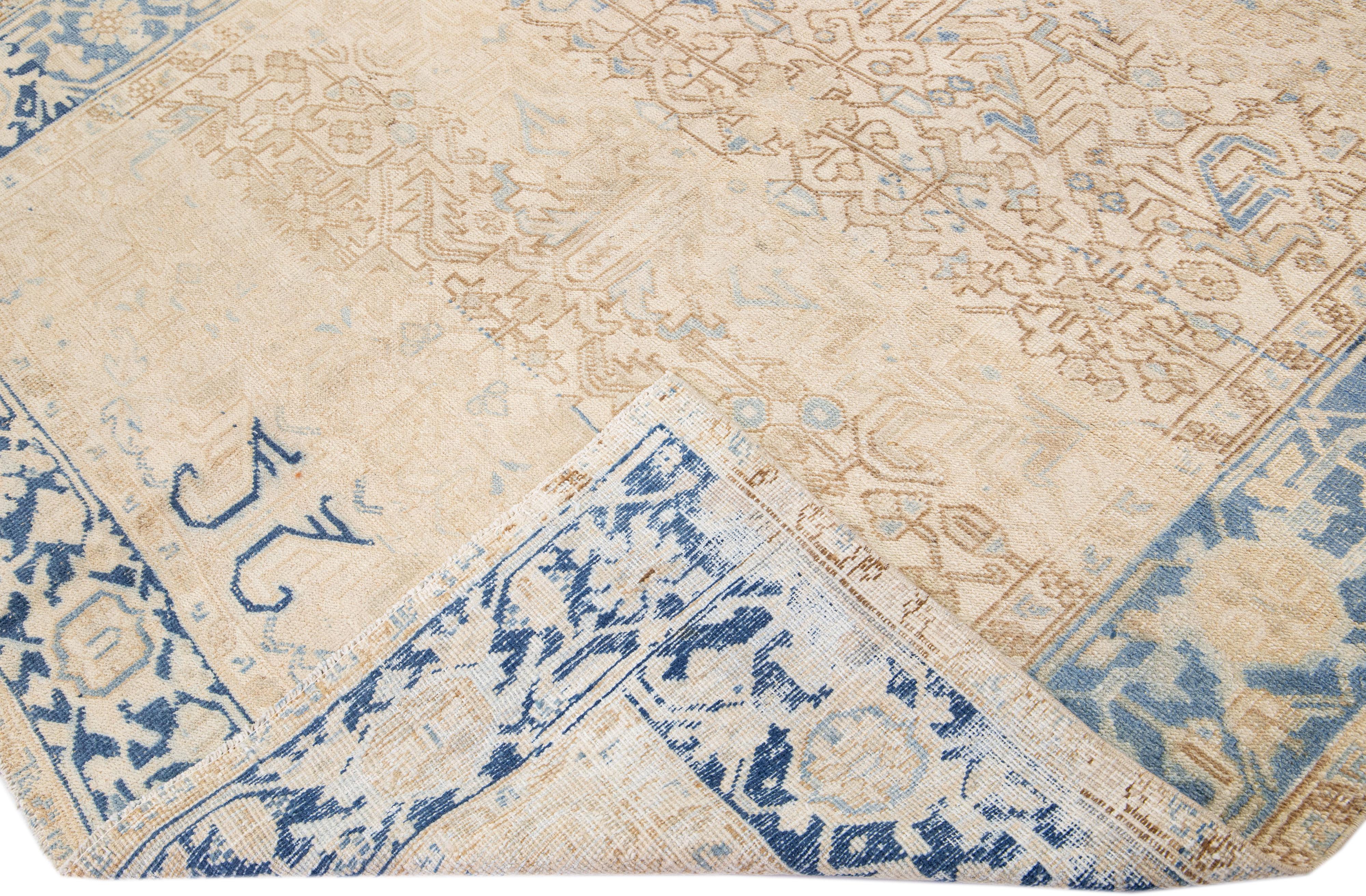 Beautiful antique Heriz hand-knotted wool rug with a beige color field. This Persian rug has a blue frame and accents in a gorgeous all-over geometric design.

This rug measures: 7'1