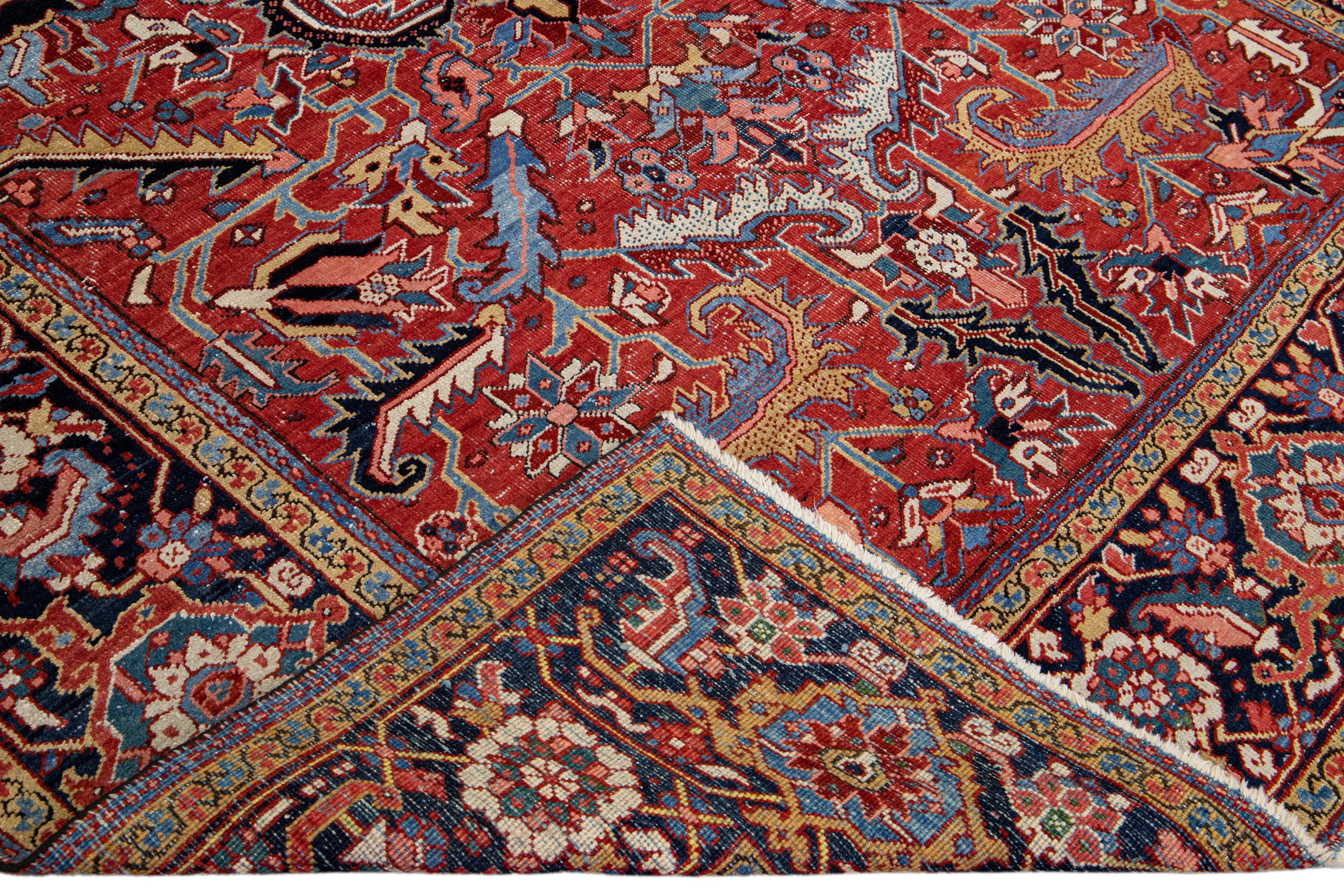 Beautiful antique Heriz hand-knotted wool rug with a red field. This Heriz rug has a navy-blue frame and multi-color accents in a gorgeous all-over geometric floral design.

This rug measures: 8' x 11'4