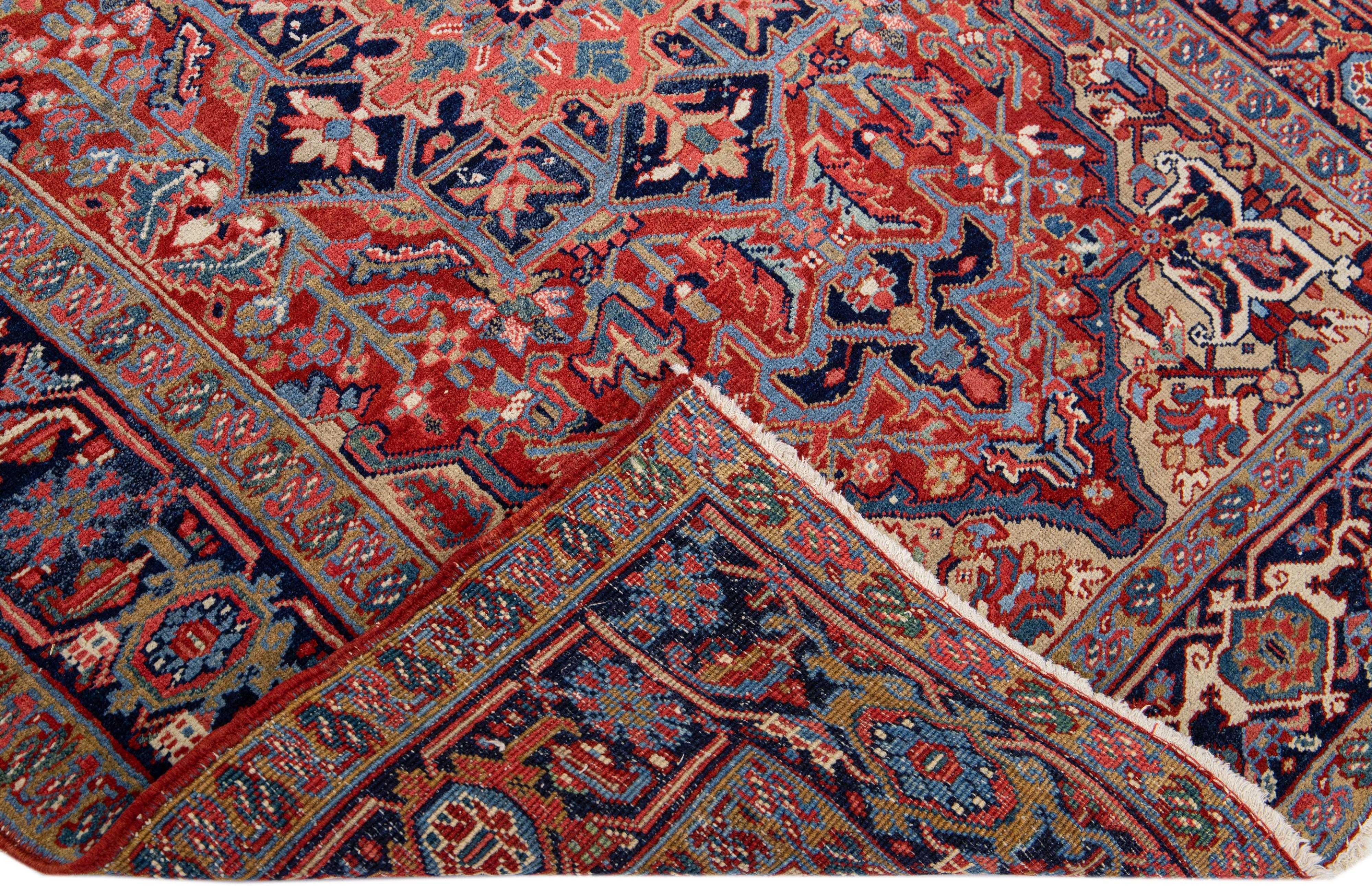 Beautiful antique Heriz hand-knotted wool rug with a red color field. This Persian rug has multicolor accents in a gorgeous medallion floral design.

This rug measures: 4'11