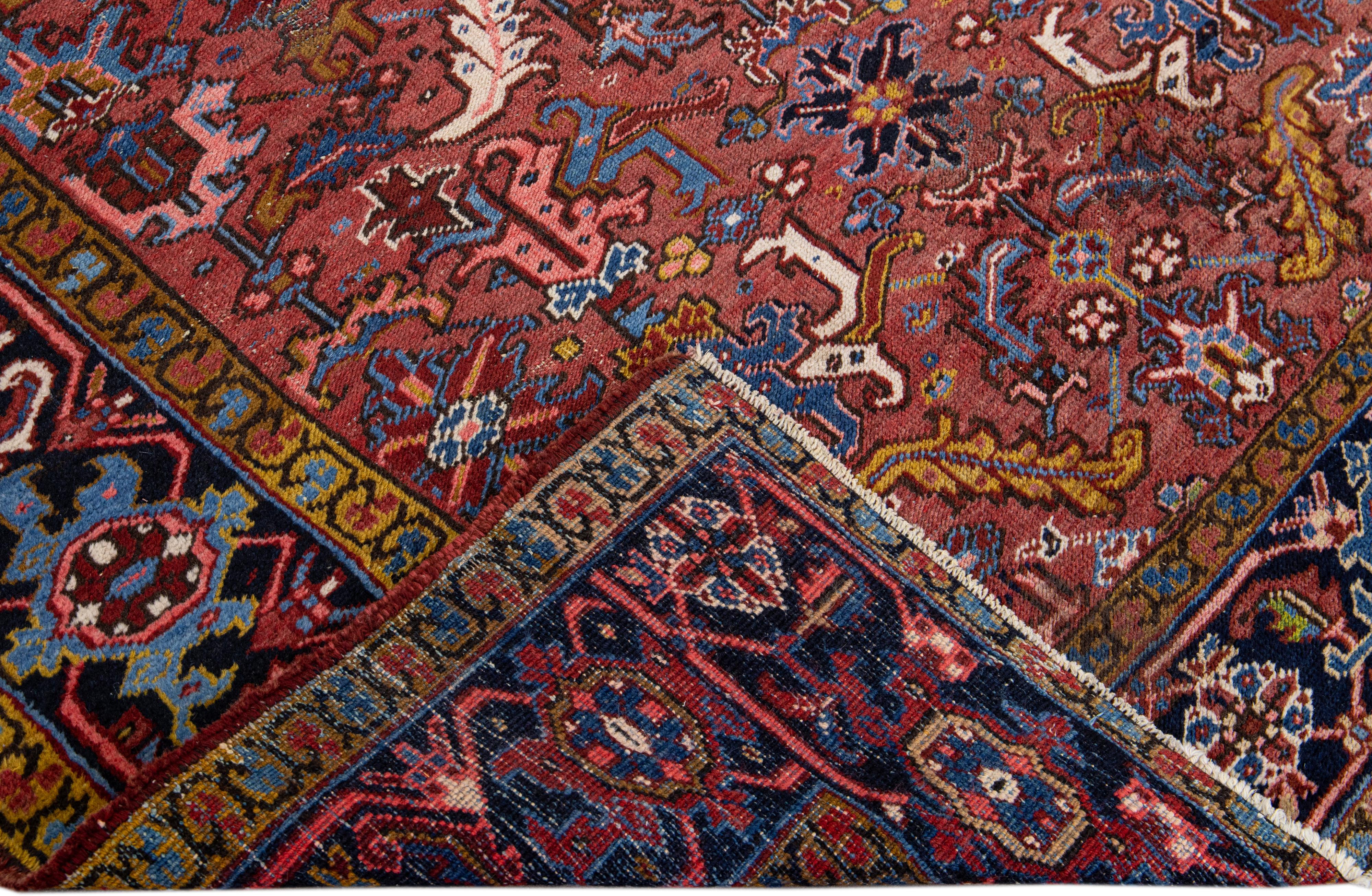 Beautiful Antique Heriz hand-knotted wool rug with a burgundy field. This Heriz rug has a navy-blue frame and multi-color accents in a gorgeous all-over geometric floral design.

This rug measures: 6'8