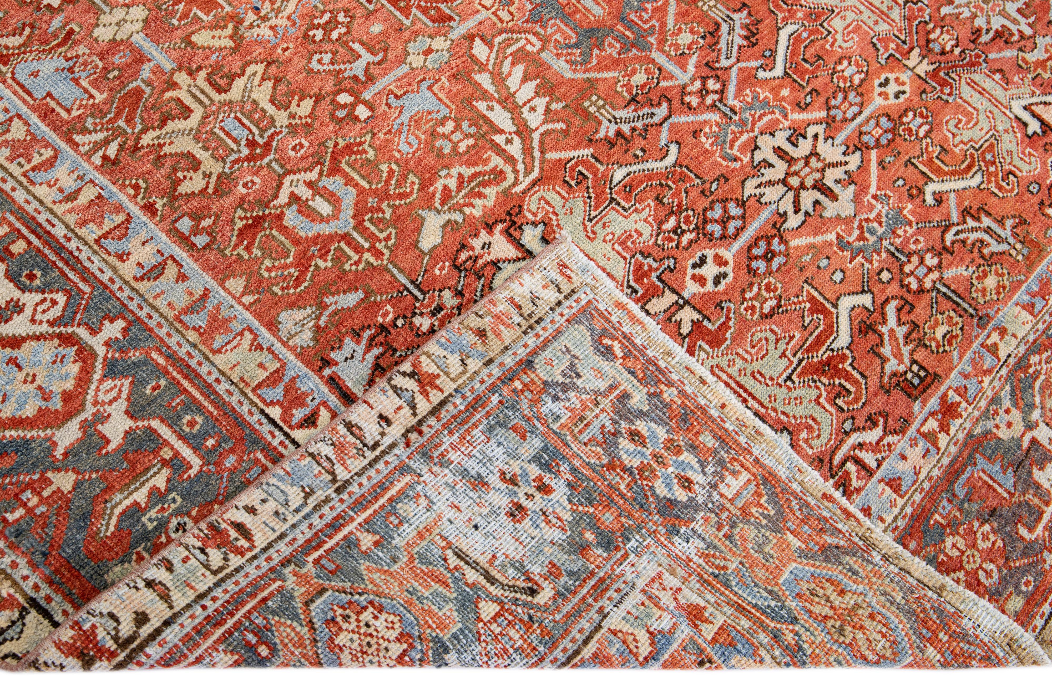 Beautiful antique Heriz Serapi hand-knotted wool rug with an orange-rust field. This Heriz rug has a blue designed frame and multi-color accents that features a gorgeous all-over floral design.

This rug measures: 7' x 9'9