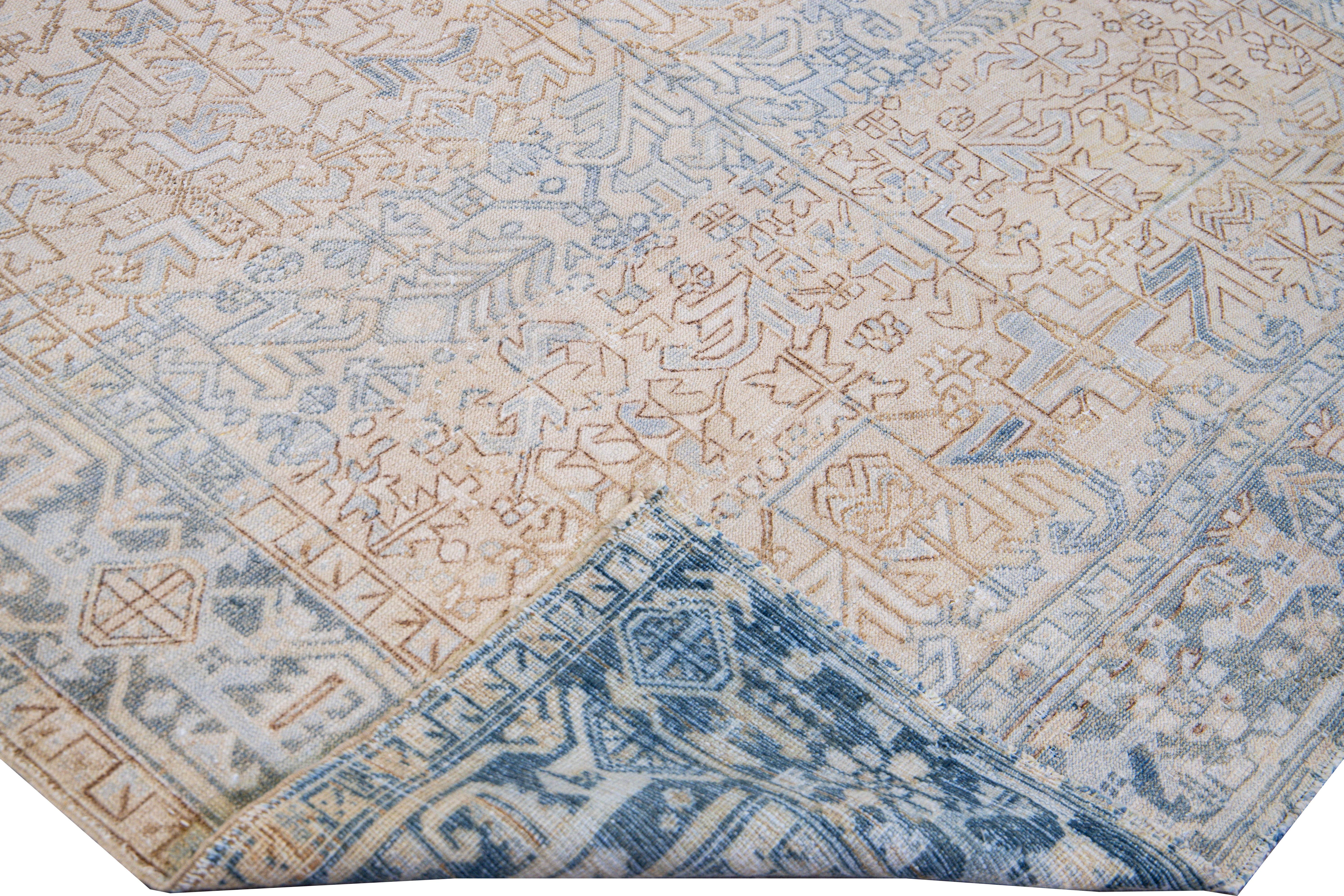 Beautiful antique Heriz hand-knotted wool rug with a beige field. This Persian rug has a blue frame and accents in a gorgeous all-over geometric floral motif.

This rug measures: 7'1