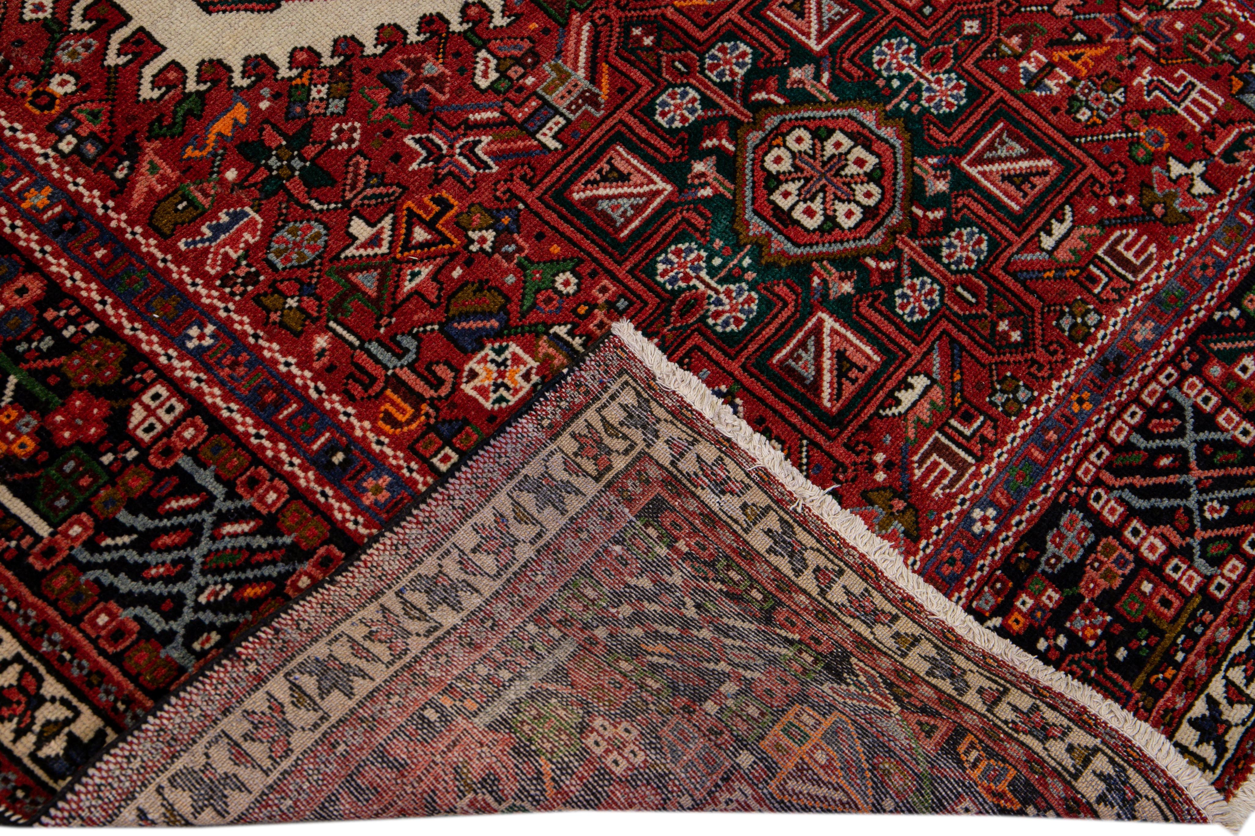 Beautiful antique Persian Heriz runner with a multi-medallion motif on a red color field. This piece has a navy-blue border and multicolor accents all over the geometric design.

This rug measures 4'10