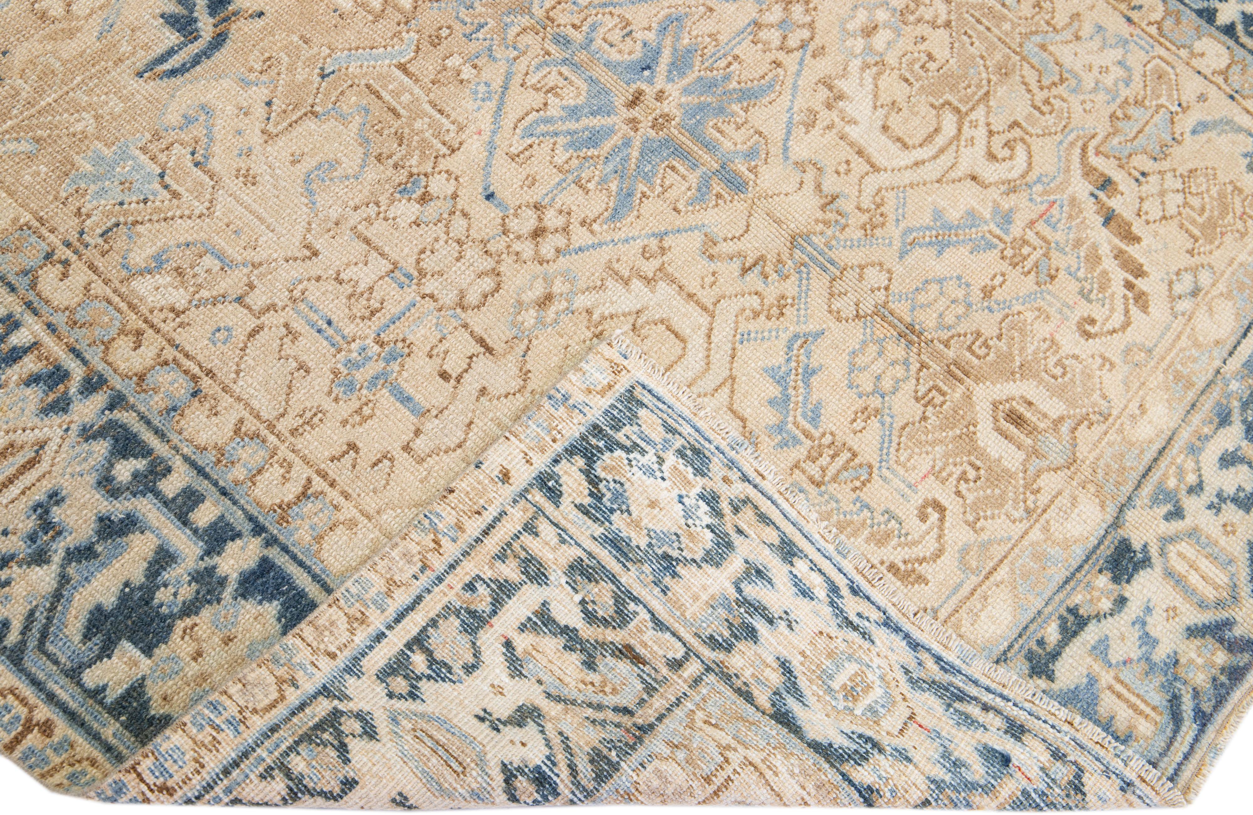 Beautiful antique Heriz hand-knotted wool rug with a beige color field. This Persian rug has a blue frame with tan accents in a gorgeous all-over geometric floral medallion design.

This rug measures: 5'6