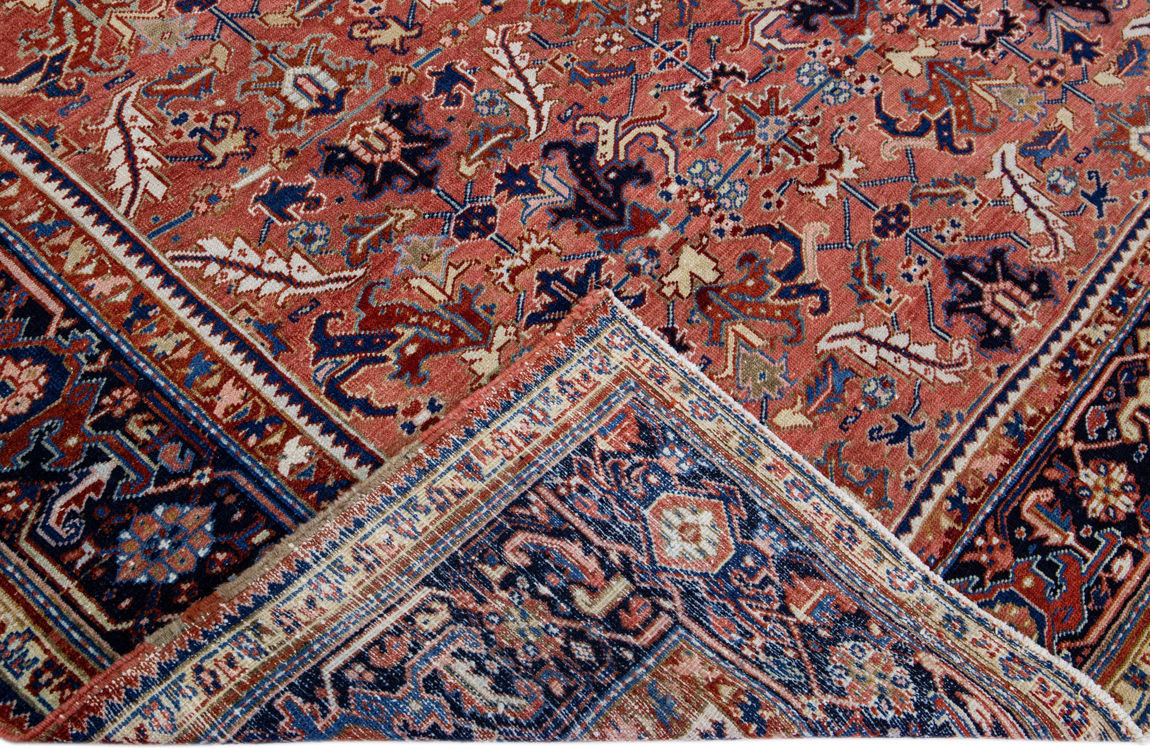 Beautiful antique Heriz Serapi hand-knotted wool rug with an orange-rust field. This Heriz rug has a navy-blue designed frame and multi-color accents that features a gorgeous all-over geometric floral design.

This rug measures: 7'10