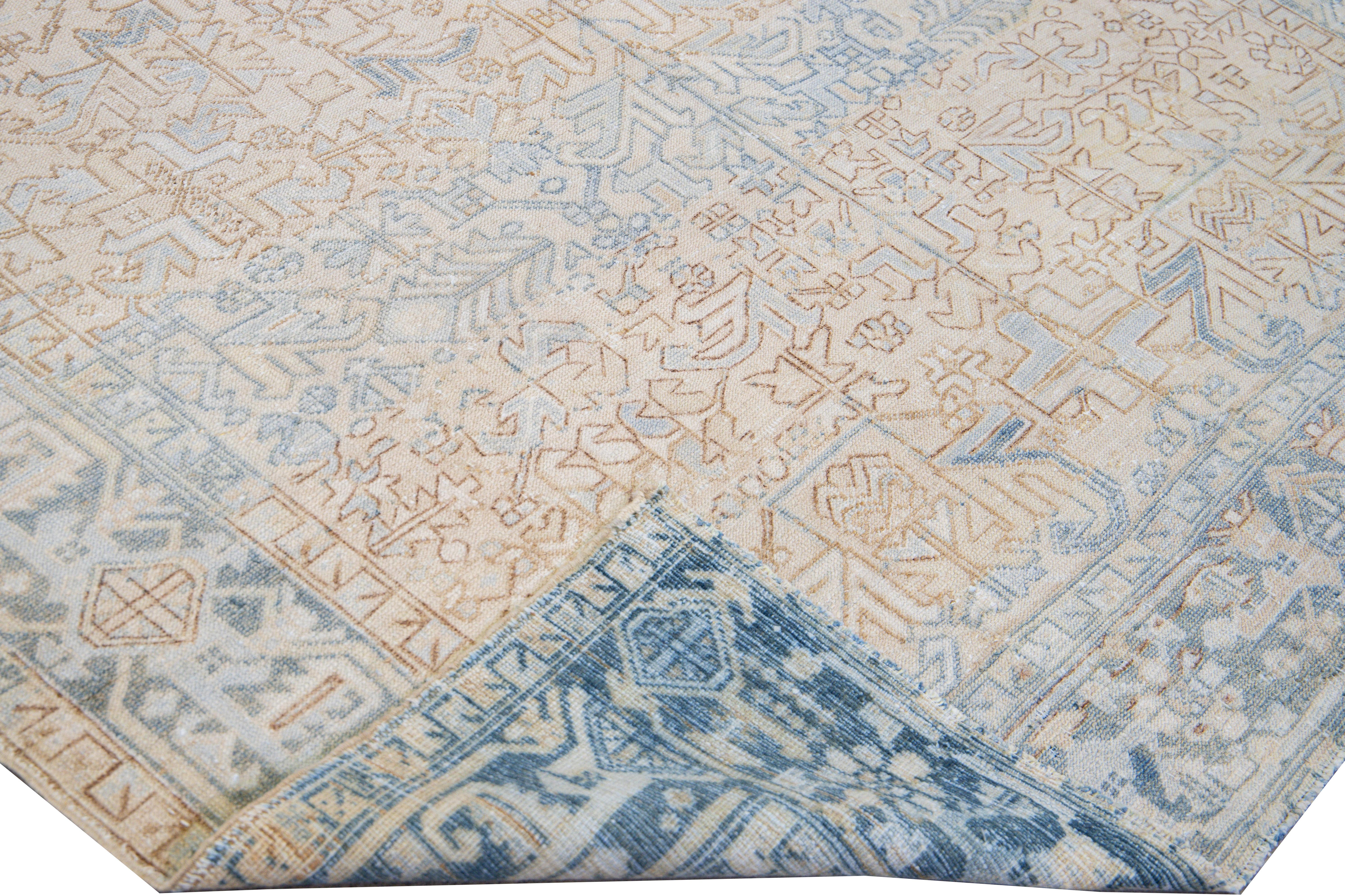 Beautiful antique Heriz hand-knotted wool rug with a beige field. This Persian rug has a blue frame and accents in an all-over gorgeous traditional geometric medallion motif design.

This rug measures: 7'8