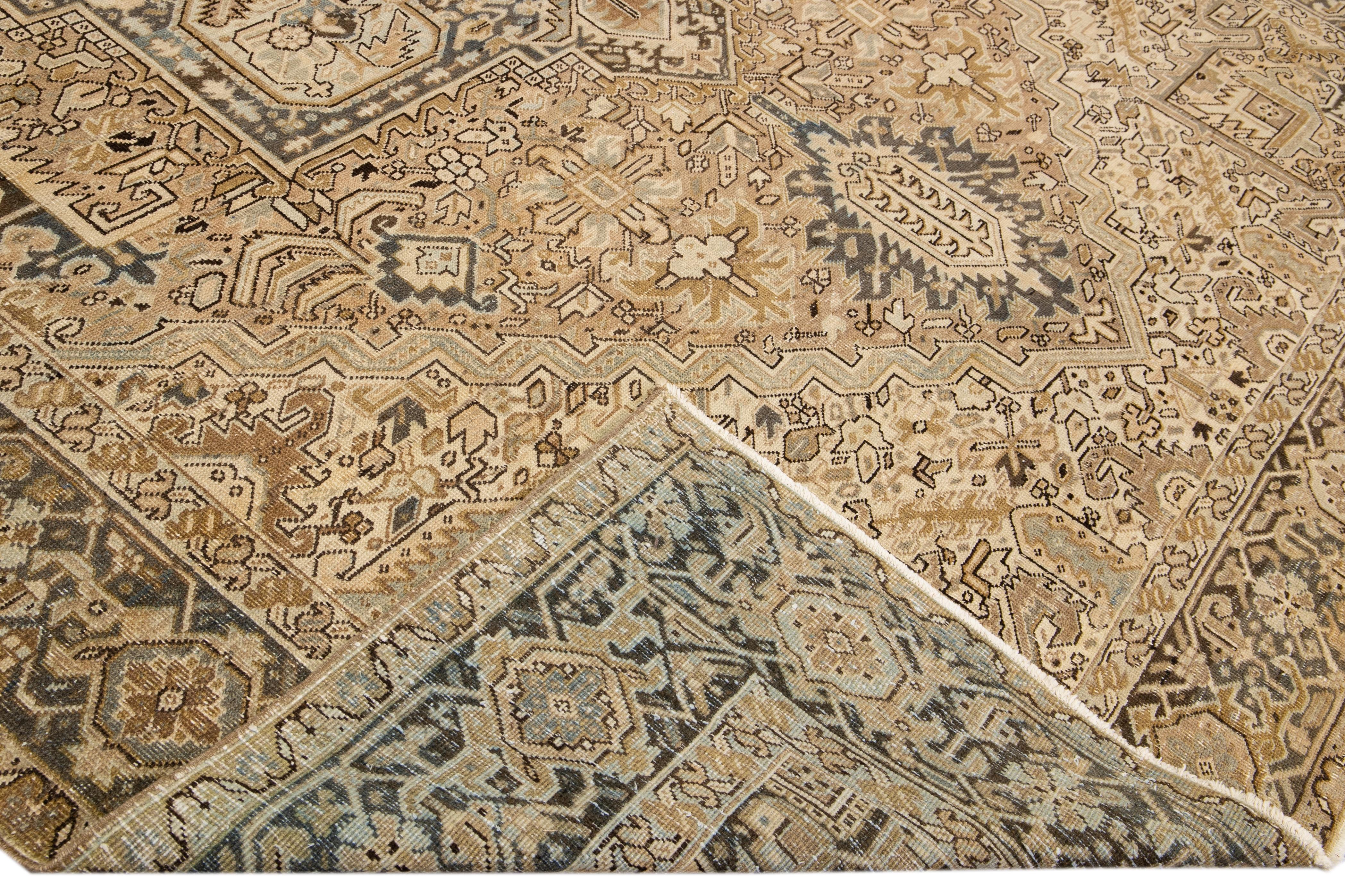 Beautiful antique Heriz hand-knotted wool rug with a beige field. This Persian rug has a blue frame and accents in a gorgeous all-over geometric floral motif.

This rug measures: 10'7