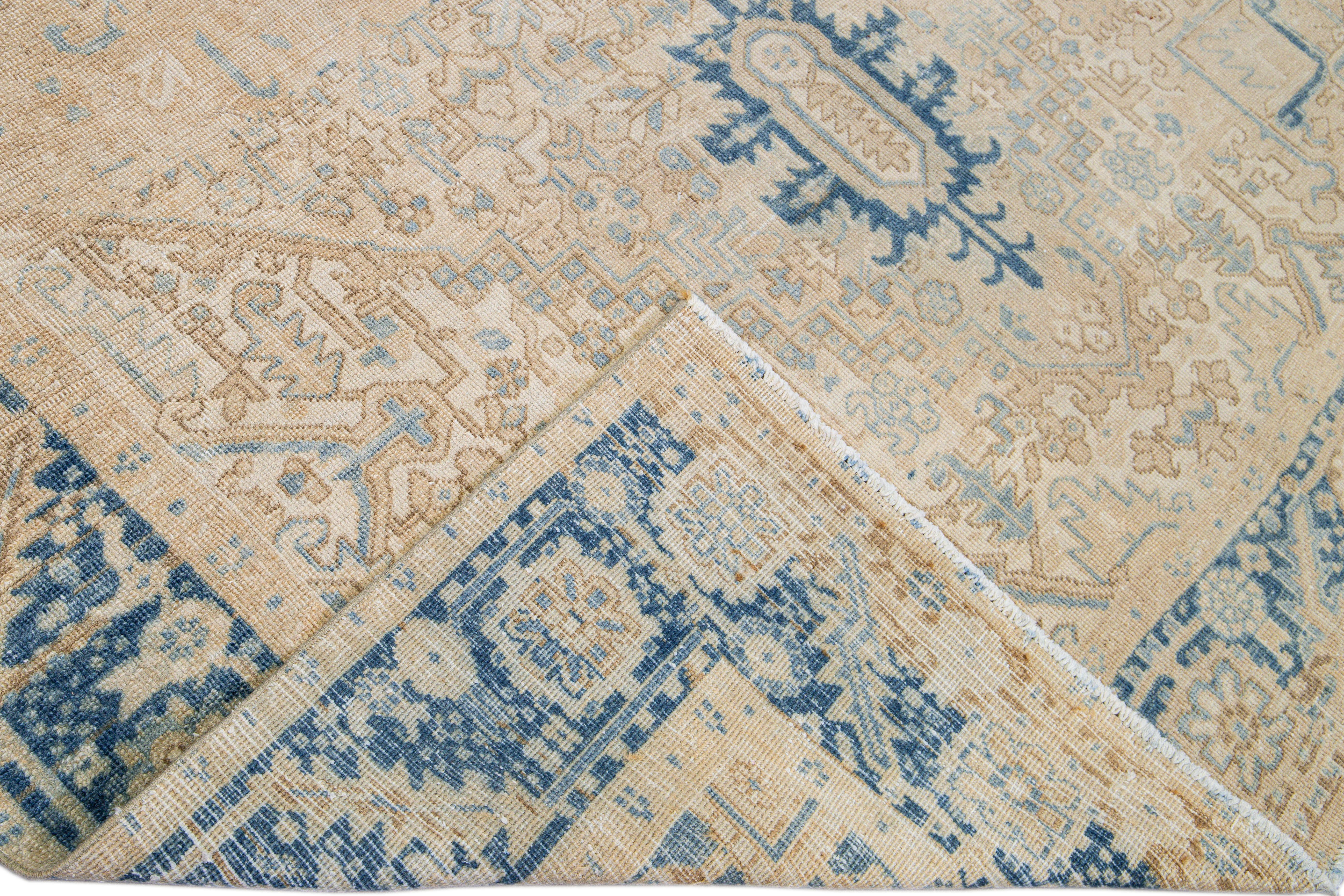 Beautiful antique Heriz hand-knotted wool rug with a beige field. This Persian rug has a blue frame and accents in a gorgeous all-over layout geometric medallion floral motif.

This rug measures: 7'8