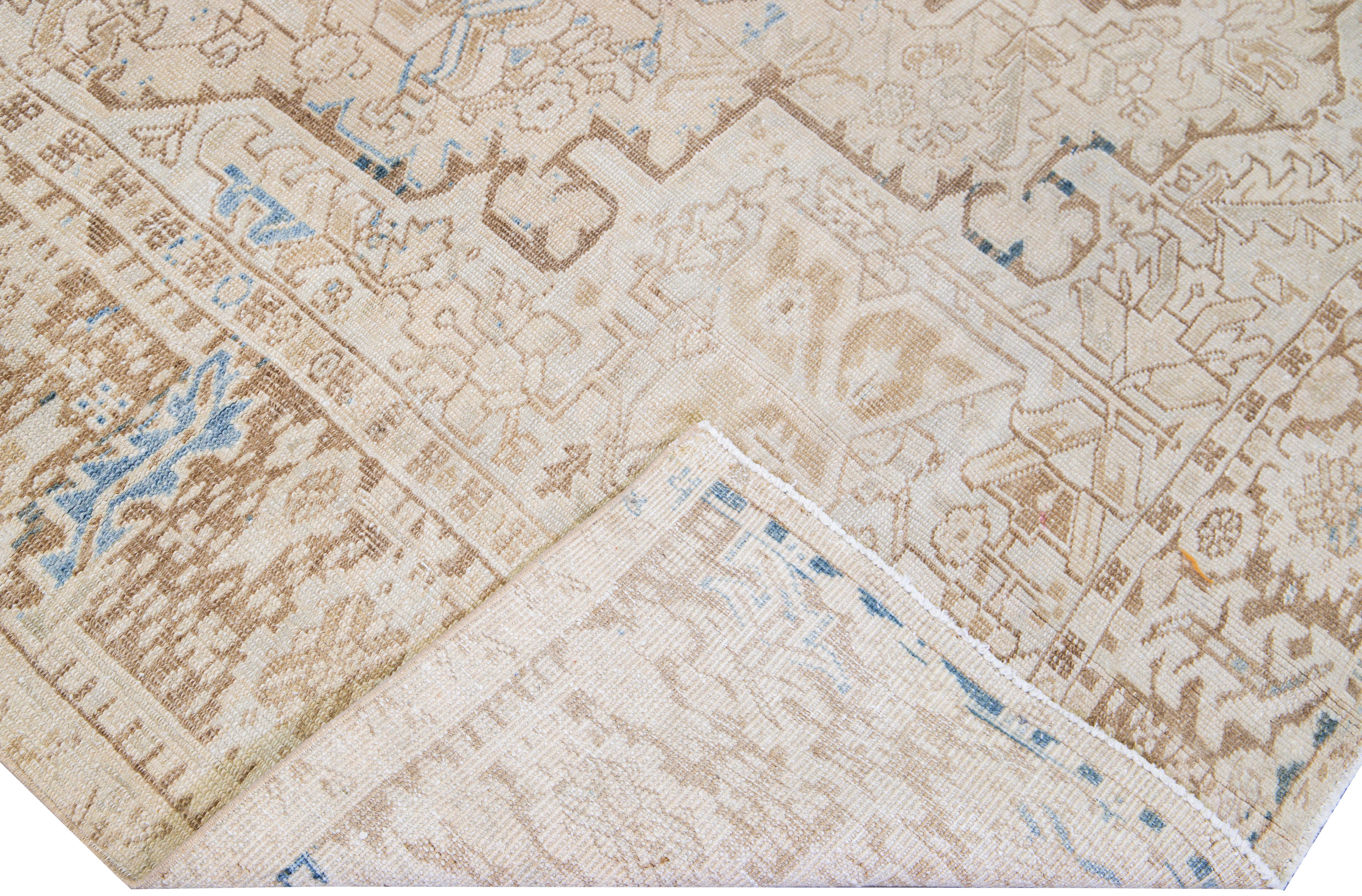 Beautiful antique Heriz hand-knotted wool rug with a beige field. This Persian rug has a tan and blue frame and accents in a gorgeous all-over layout geometric medallion floral motif.

This rug measures: 8' x 10'11