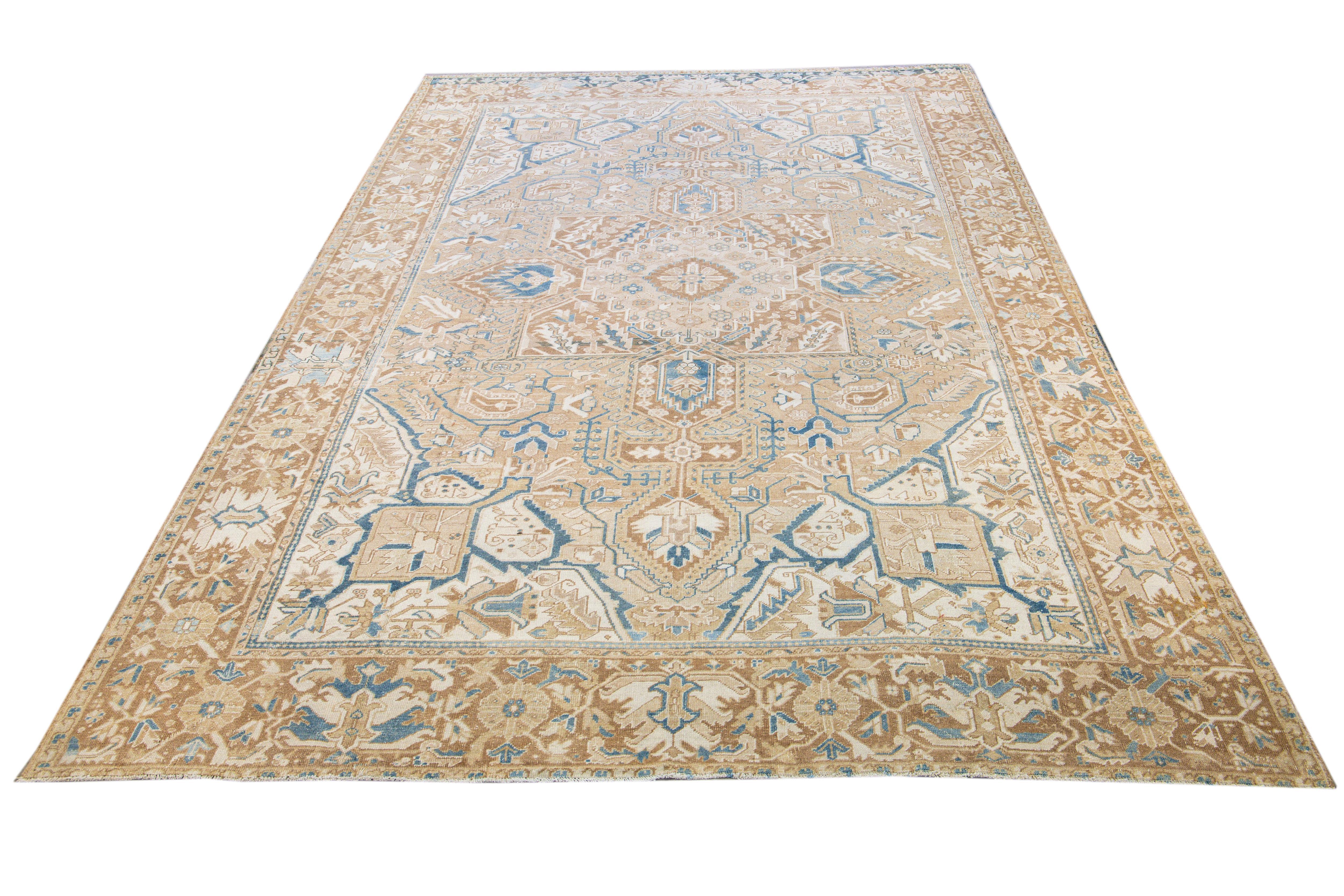 Beautiful antique Heriz hand-knotted wool rug with a tan field. This Persian rug has a blue and ivory accent in a gorgeous all-over layout geometric medallion floral motif.

This rug measures: 9'3
