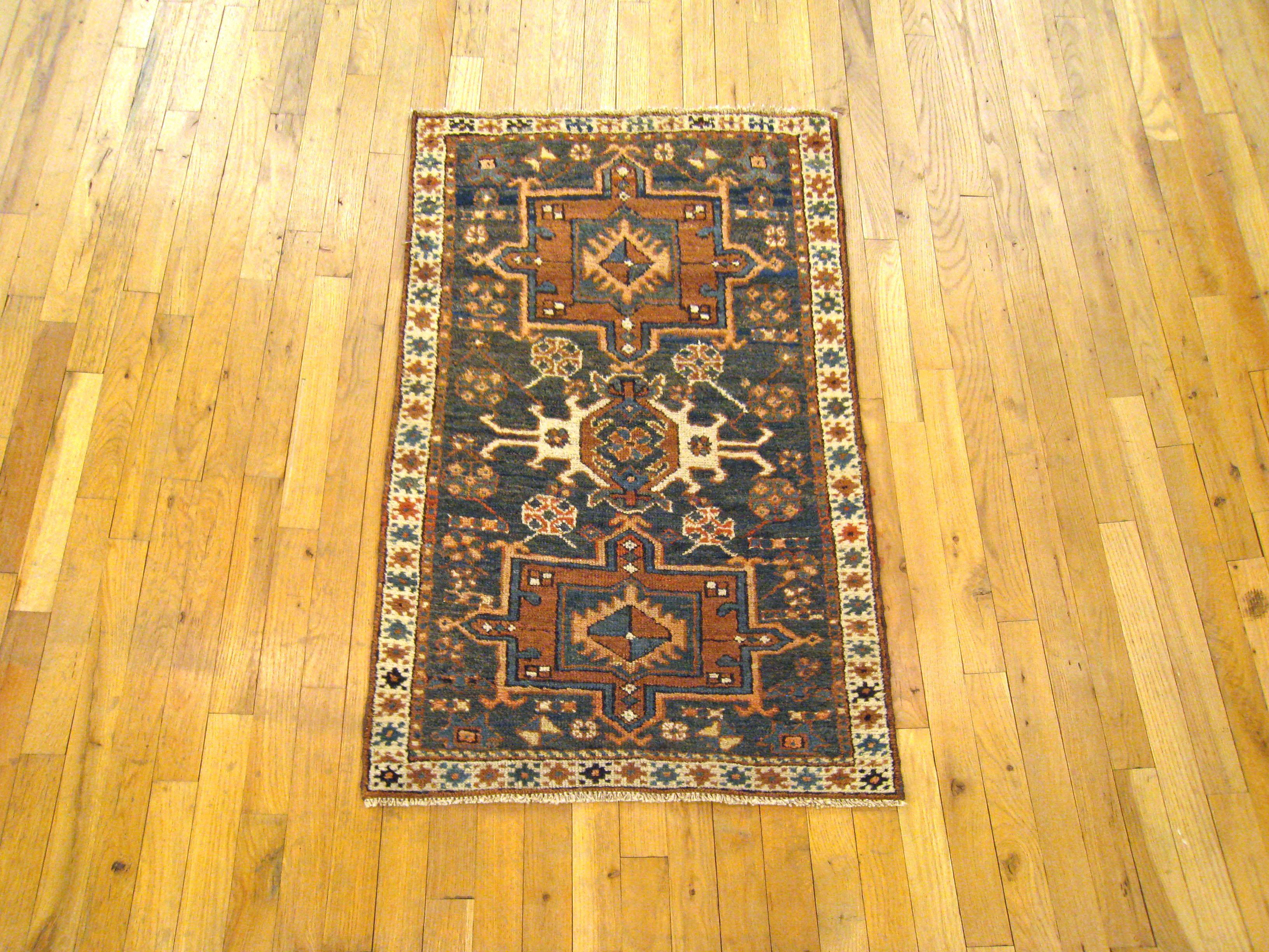An antique Persian Heriz Karaja oriental rug, size 3'8 H x 2'3 W, circa 1900. This handsome handwoven rug features a symmetrical series of medallions on a blue green field that has a variety of Traditional Design elements and symbols. The field is