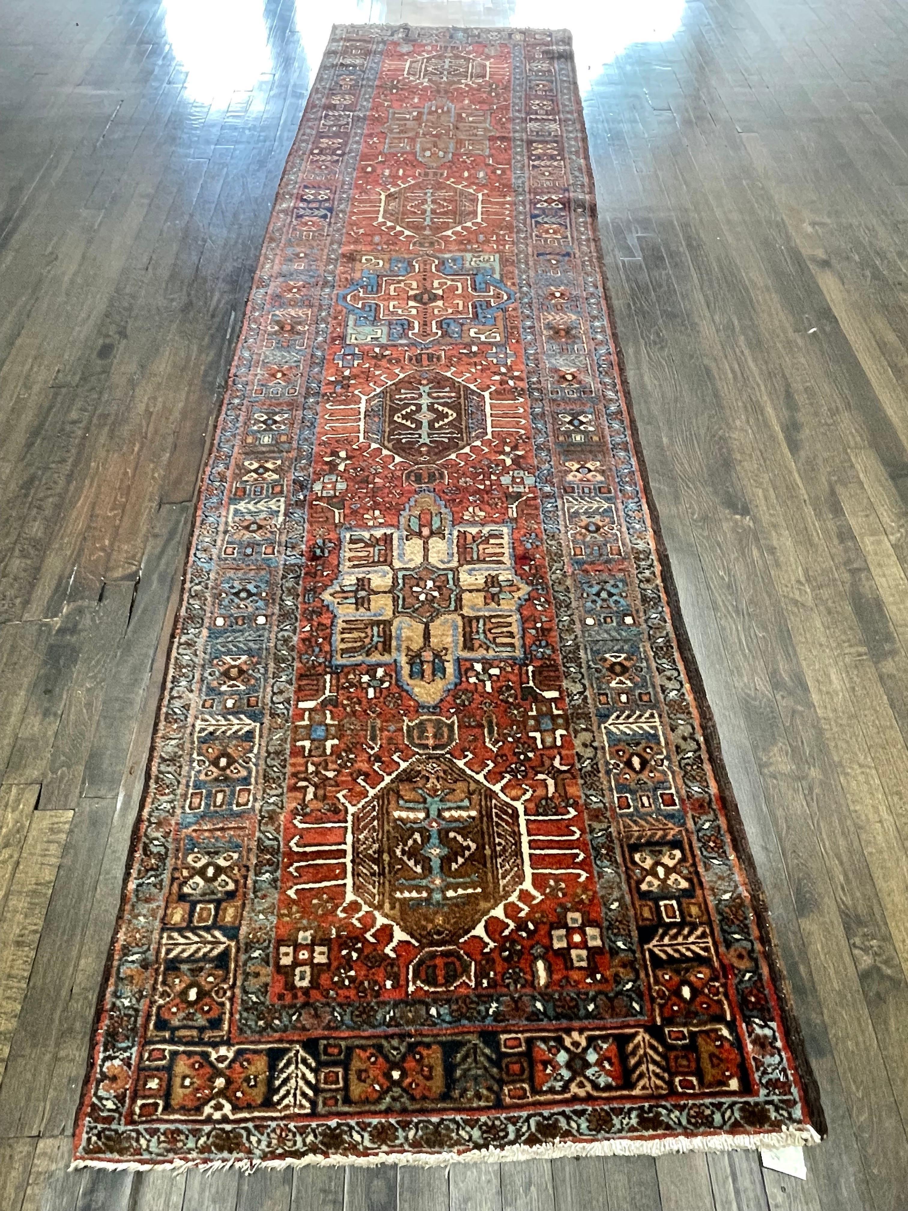 A handsome and rare runner handmade in the town of Karaja northwest Iran.Featuring dark walnut field decorated by signature karaja medallions.The runner is framed by a navy blue main dorder and two lighter blue guard borders.The background design is