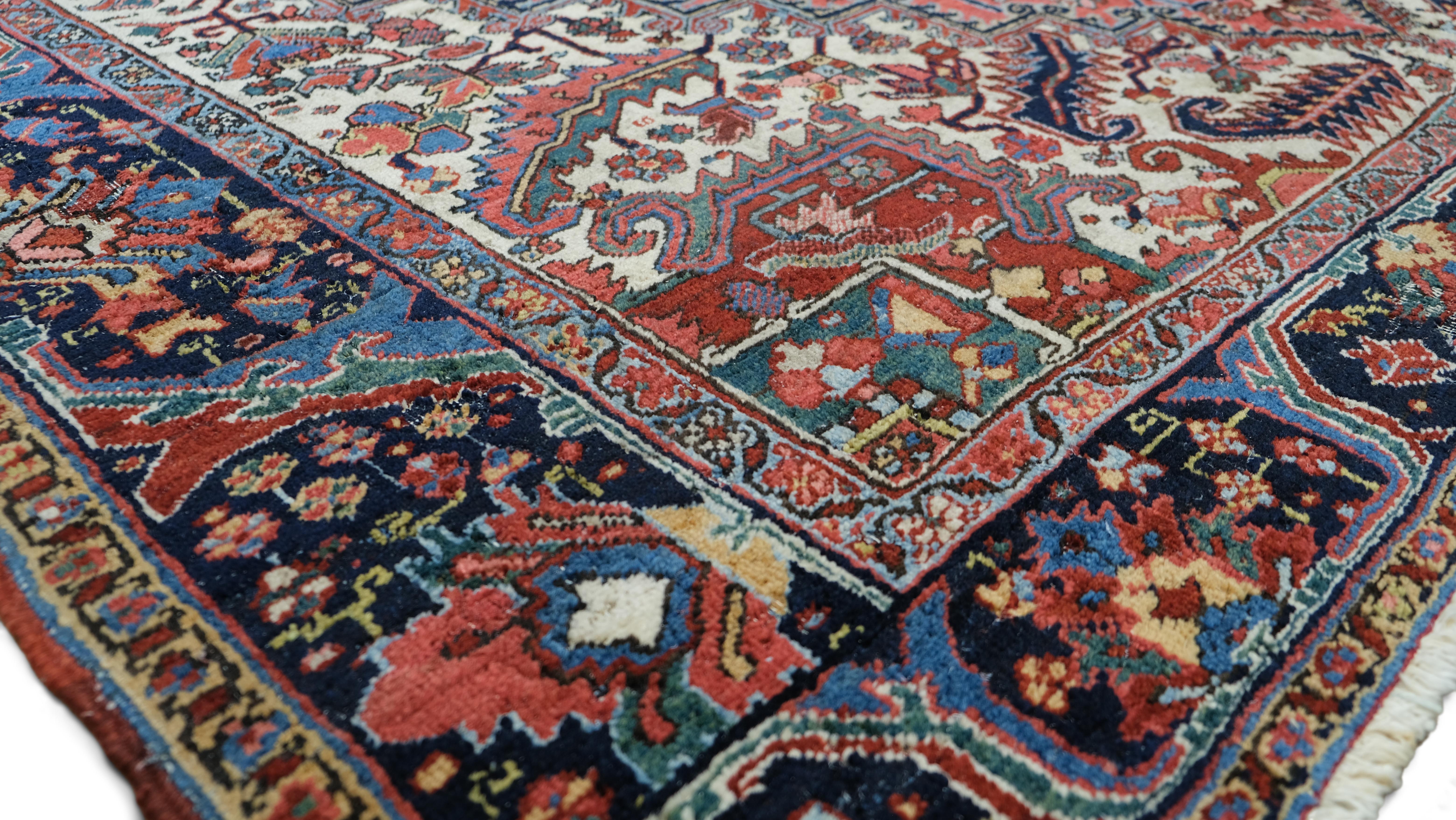 Dieser antike Heriz-Teppich ist ein atemberaubendes Beispiel traditioneller iranischer Handwerkskunst. Er besteht aus handgeknüpfter Wolle und ist für seine Haltbarkeit und Kunstfertigkeit bekannt. Das kühne geometrische Medaillon in der Mitte,