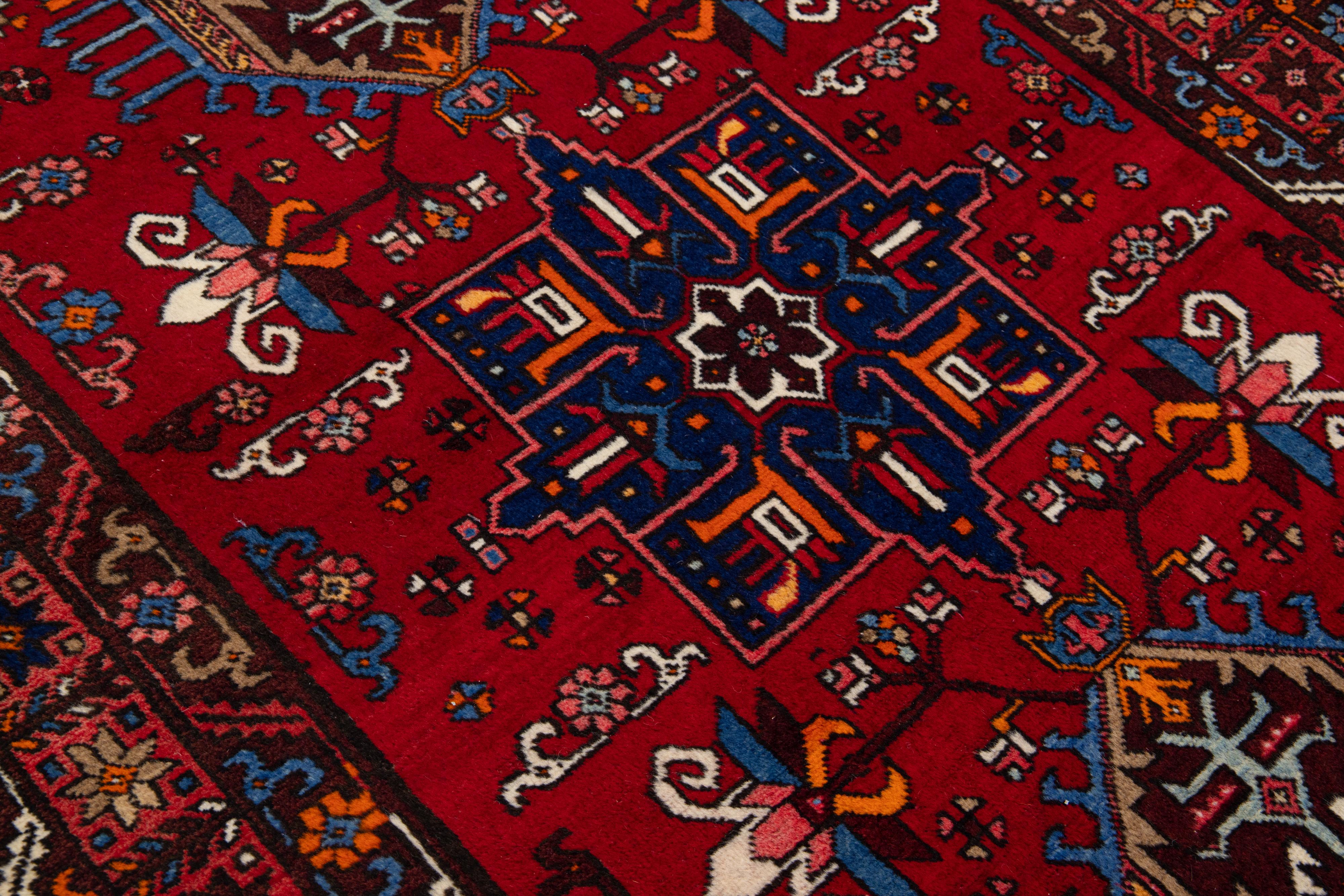 Beautiful antique Heriz hand-knotted wool rug with a red color field. This Persian rug has a designed frame and multicolor accents in a gorgeous Tribal design.

This rug measures: 4'10