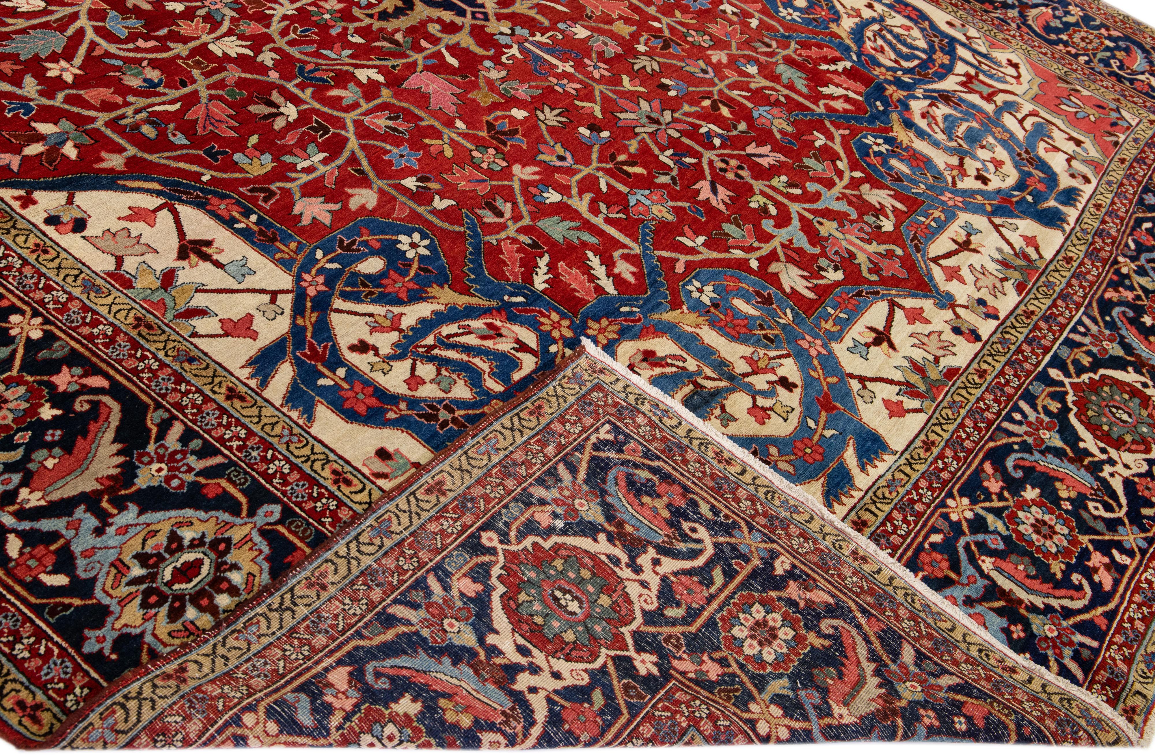Beautiful Antique Heriz hand-knotted wool rug with a red field. This Persian rug has multi-color accents that feature a gorgeous all-over geometric floral medallion design.

This rug measures: 11'8