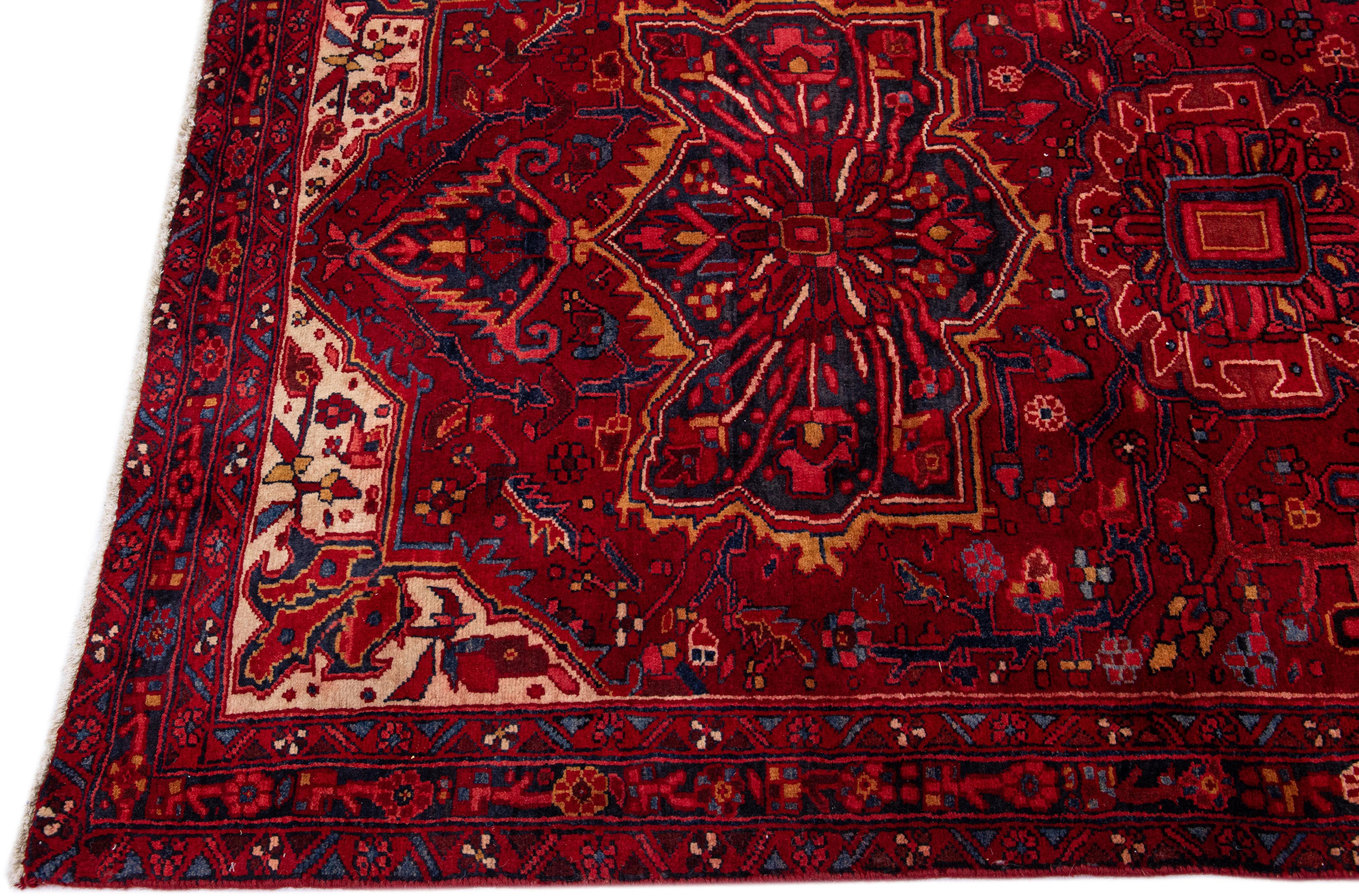 Beautiful antique Heriz hand-knotted wool rug with a red color field. This Persian rug has multicolor accents in a gorgeous all-over floral pattern.

This rug measures: 5'1