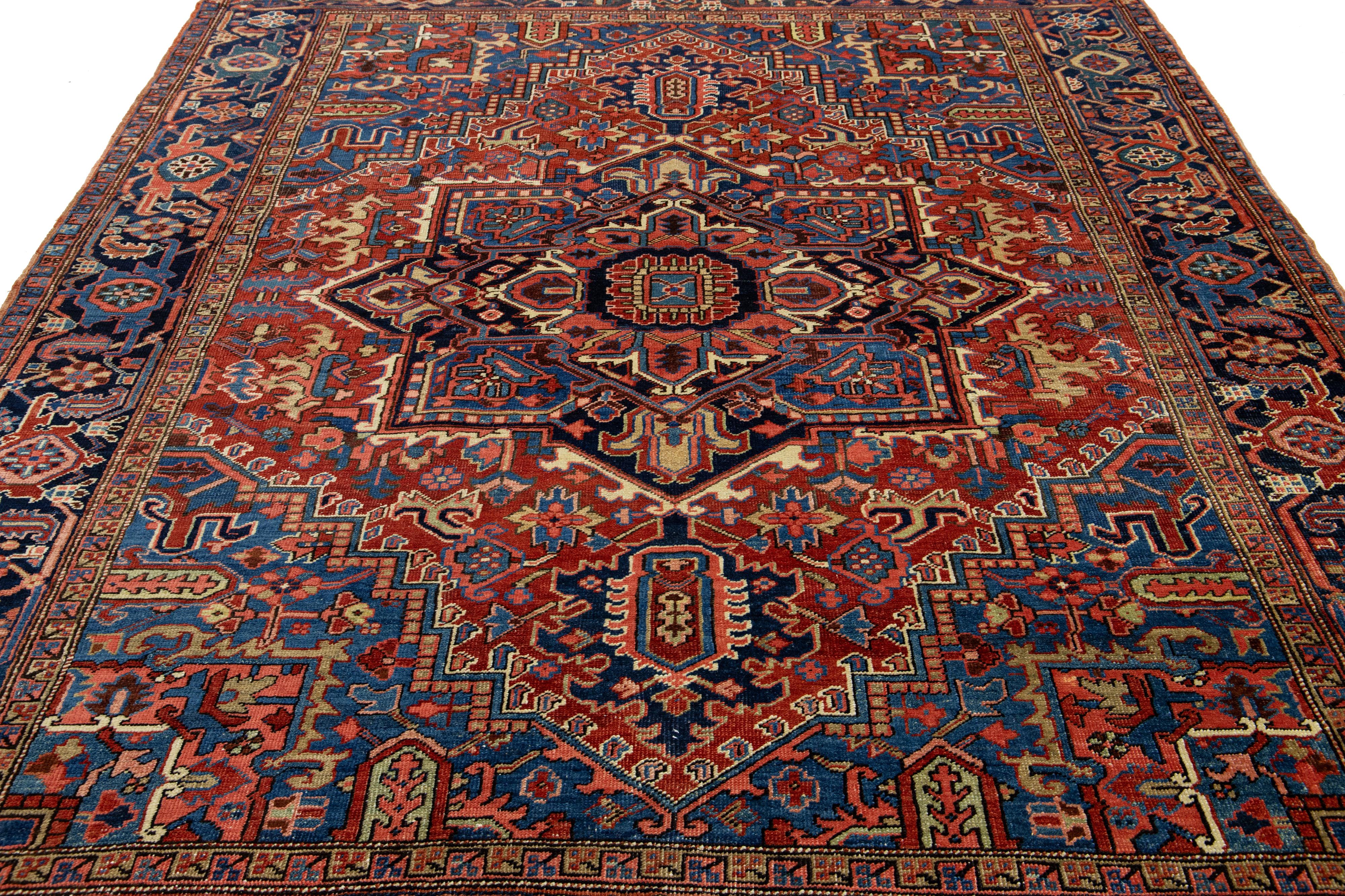 Explora el exquisito encanto de esta antigua alfombra persa de lana Heriz. Con un cautivador diseño de medallón multicolor, infunde vitalidad a un rico y profundo fondo azul y rojo.

Esta alfombra mide 7'3'' x 9'1
