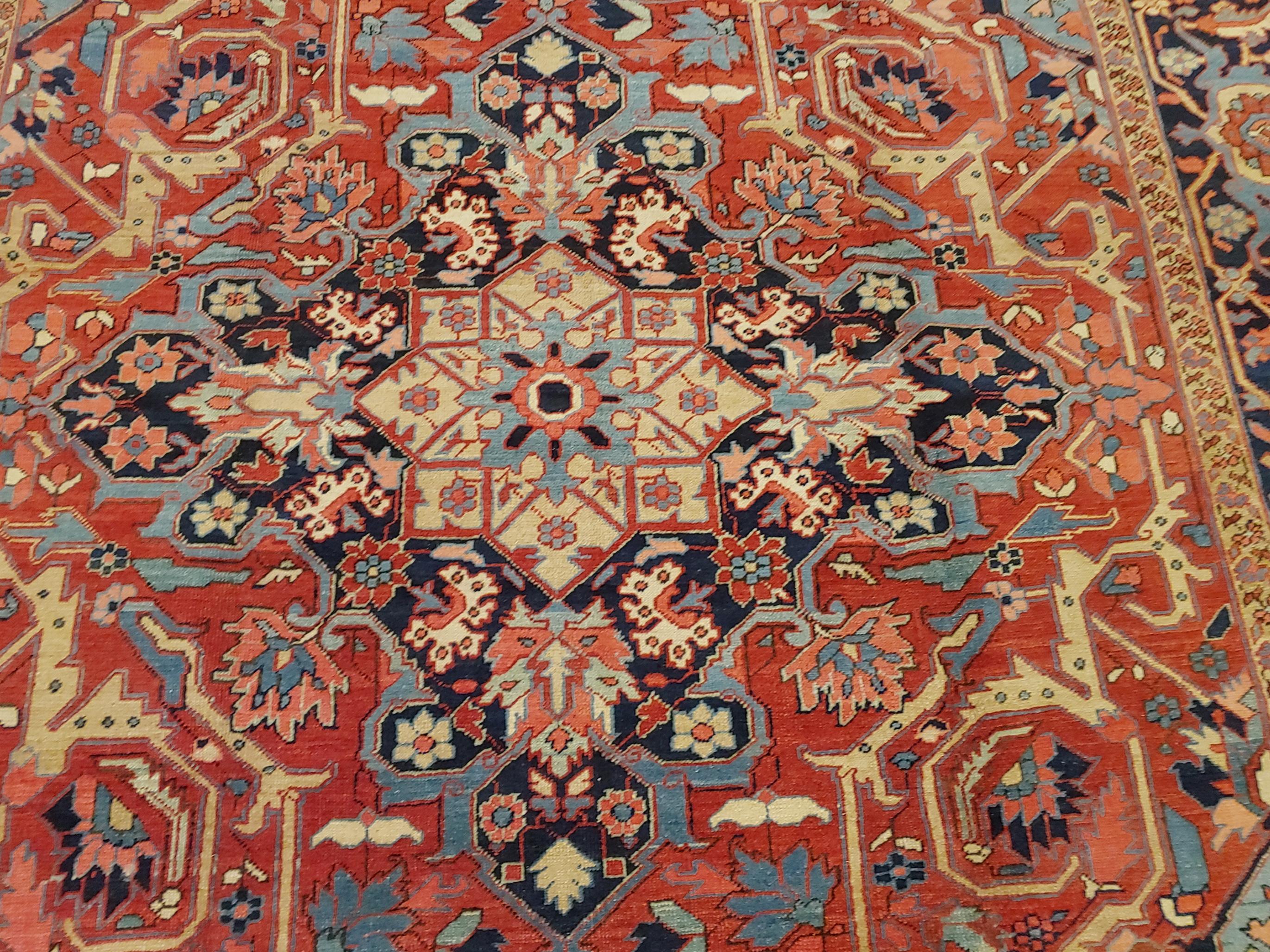 This is a striking early Persian Heriz. It has all of the attributes of a Bakshaish. It is a room size 9-5 x 11-7 with elegant light blue corners on a rust field decorated with gold tendrils and a navy border.