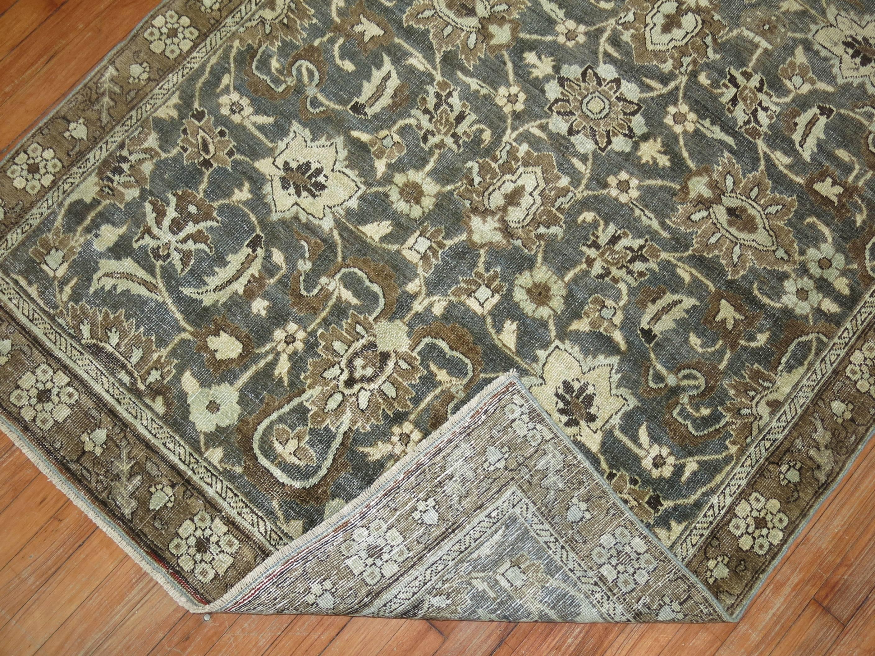 An early 20th century Persian Heriz rug predominantly in dark green.

Measures: 4'2''x 6'