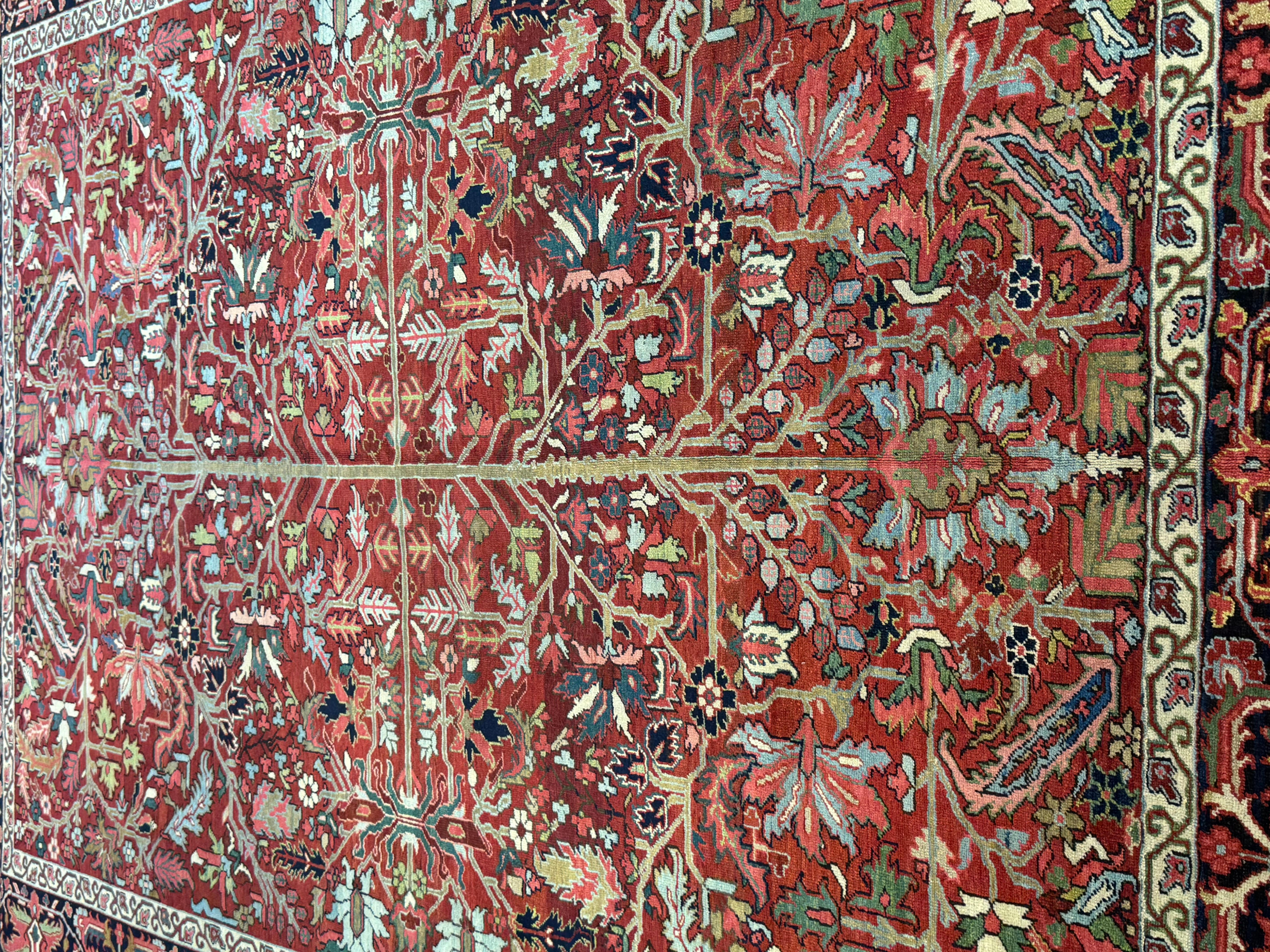 Dieser exquisite antike persische Heriz-Teppich aus dem Iran der frühen 1900er Jahre ist ein bemerkenswertes Beispiel für persische Handwerkskunst, Geschichte und Kunstfertigkeit. Dieser Teppich wurde von Meisterhandwerkern mit altehrwürdigen