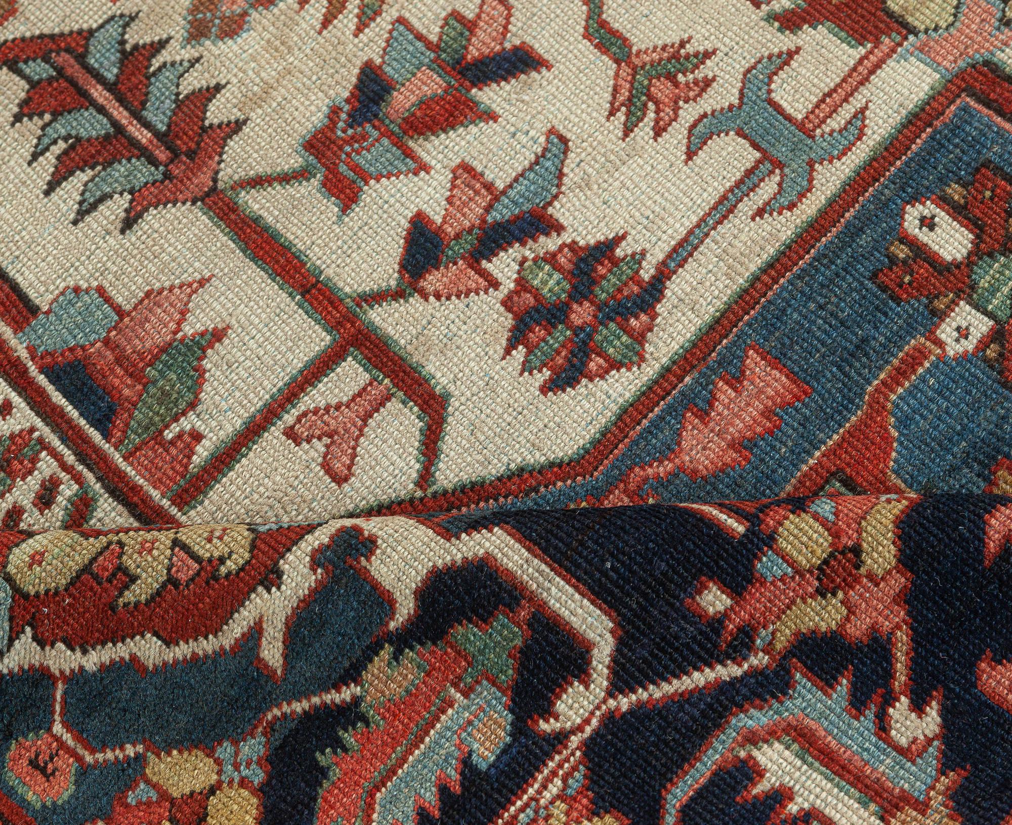 One-of-a-kind antique Persian Heriz rug in beige, blue, pink, and red.
Size: 11'10