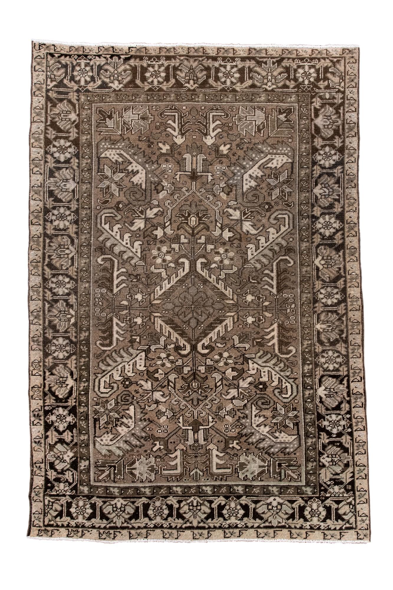 Questo antico tappeto Heriz presenta un grande medaglione centrale circondato da audaci motivi angolari e da un classico bordo floreale-geometrico. La tavolozza morbida e neutra conferisce al design Heriz, tradizionalmente grafico, un aspetto più