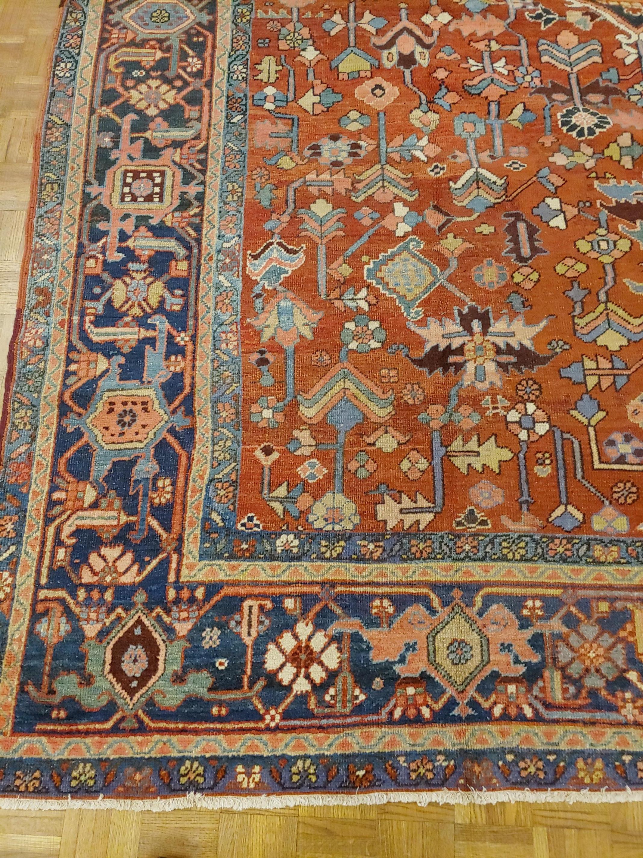 Great looking Persian antique Heriz which many dealers would call a Serapi. The rug has an impressive harmony of design and colors on a rust field with no medallion and a navy border with Classic geometric herati motif, circa 1915. Room size, size: