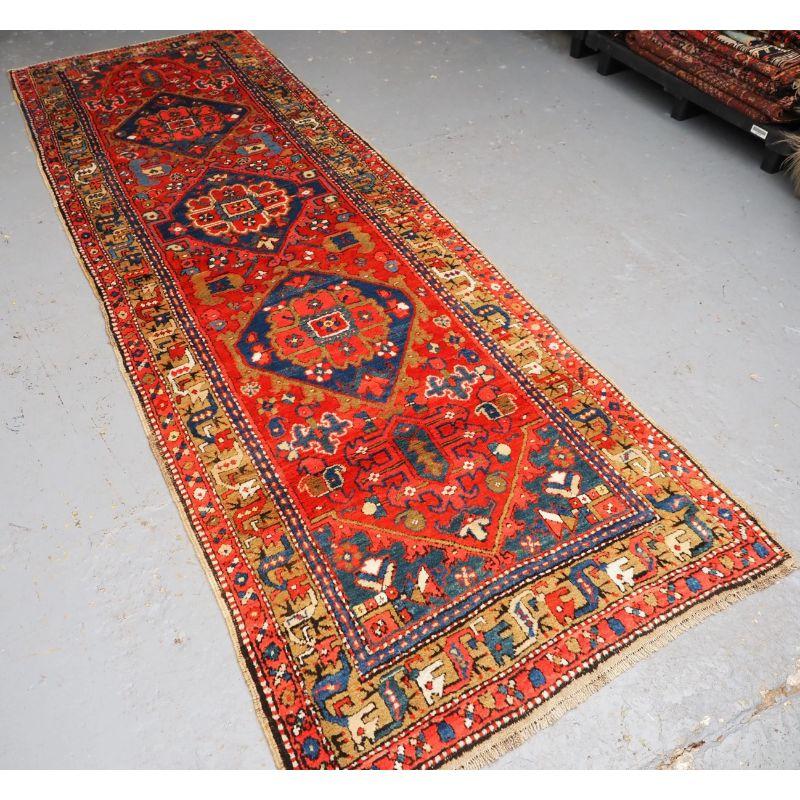 Antiker persischer Heriz-Teppich von guter Größe, mit traditionellem Muster.

Der Läufer hat ein traditionelles Heriz-Medaillon-Muster auf einem terrakottaroten Grund, die Medaillons sind in Indigoblau-Tönen gehalten. Die Bordüre ist sehr gut